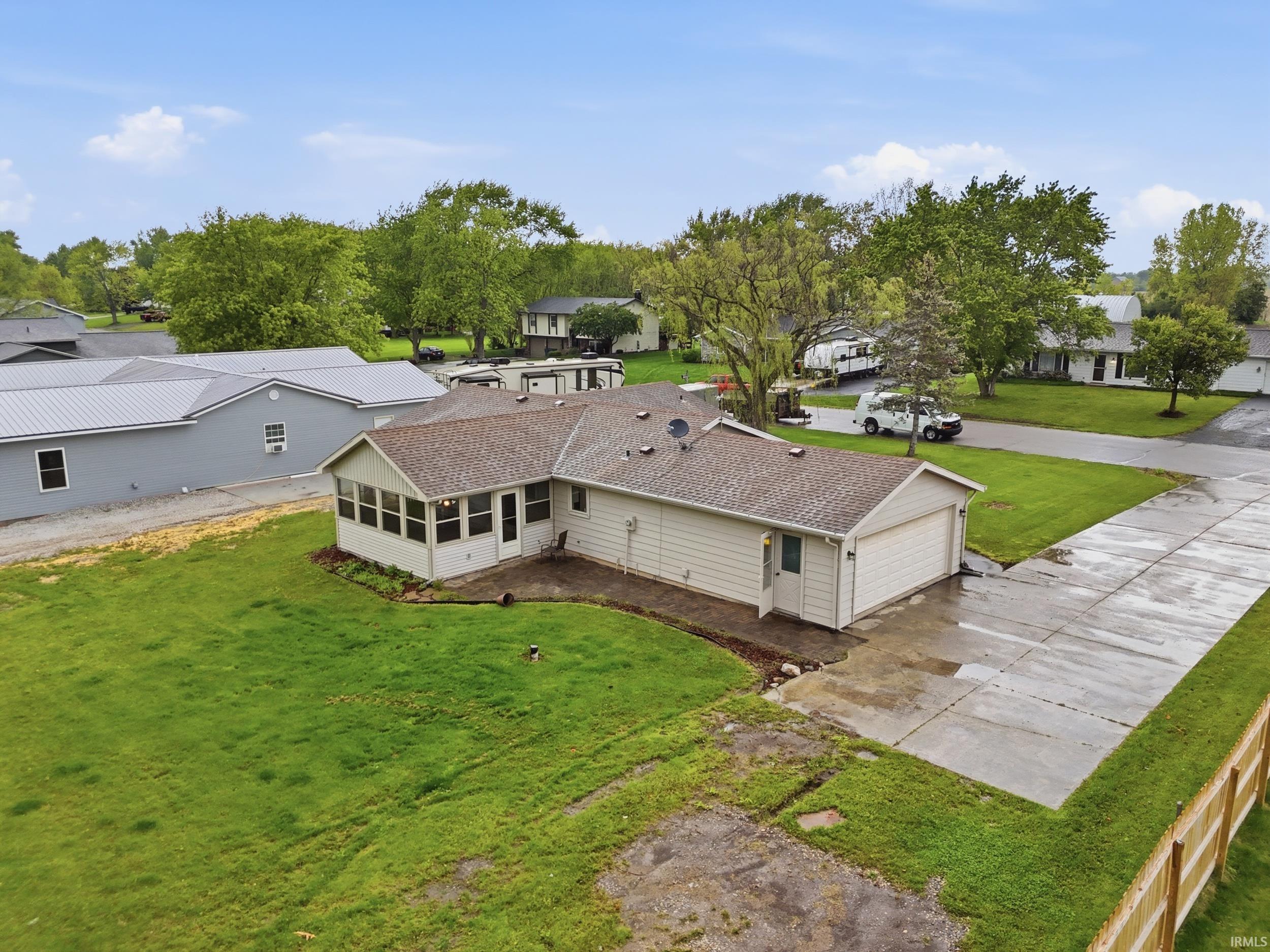 Single-story residence featuring a covered sunroom, attached two-car garage, and concrete driveway