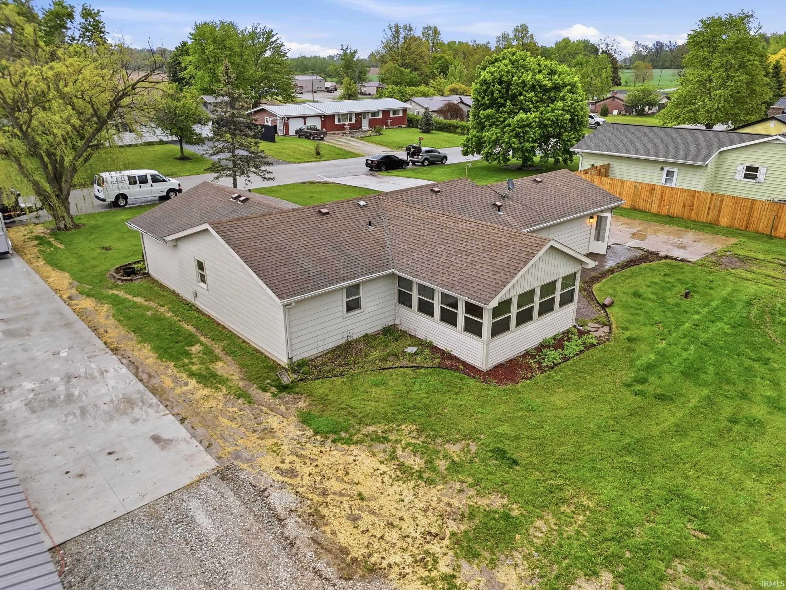 Expansive property featuring a sunroom addition, shingle roofing, and a gravel driveway