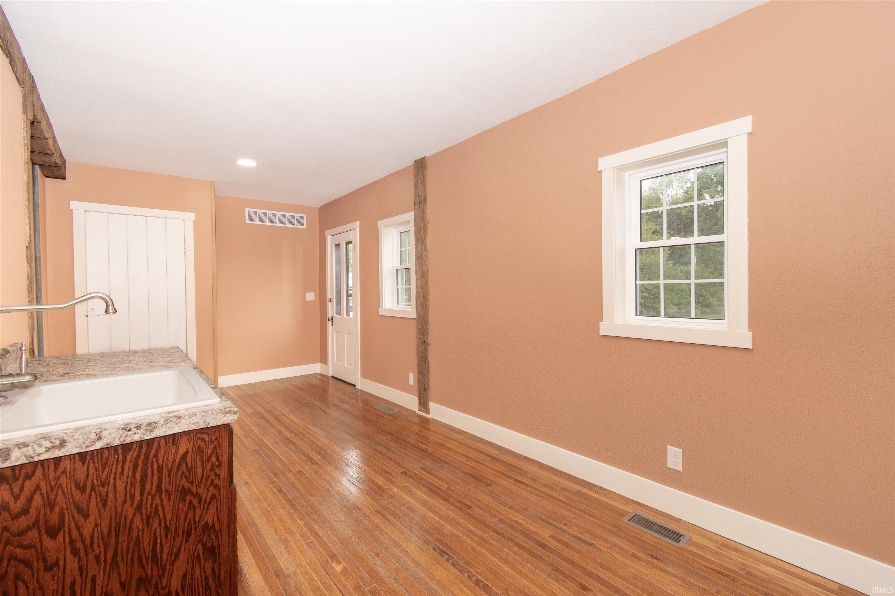 Hardwood flooring throughout featuring exposed wood beams