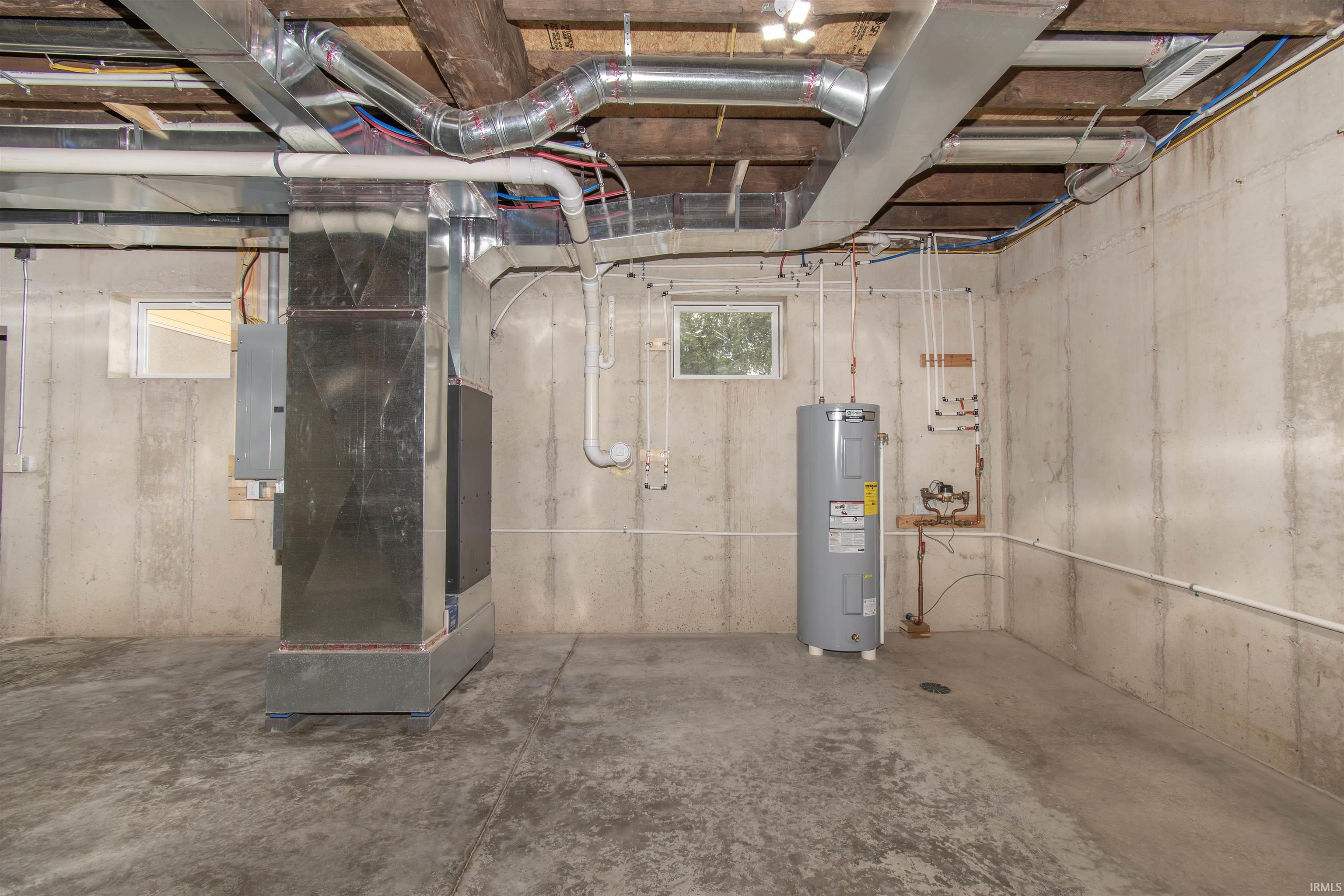 Unfinished basement with concrete flooring and exposed ceiling joists