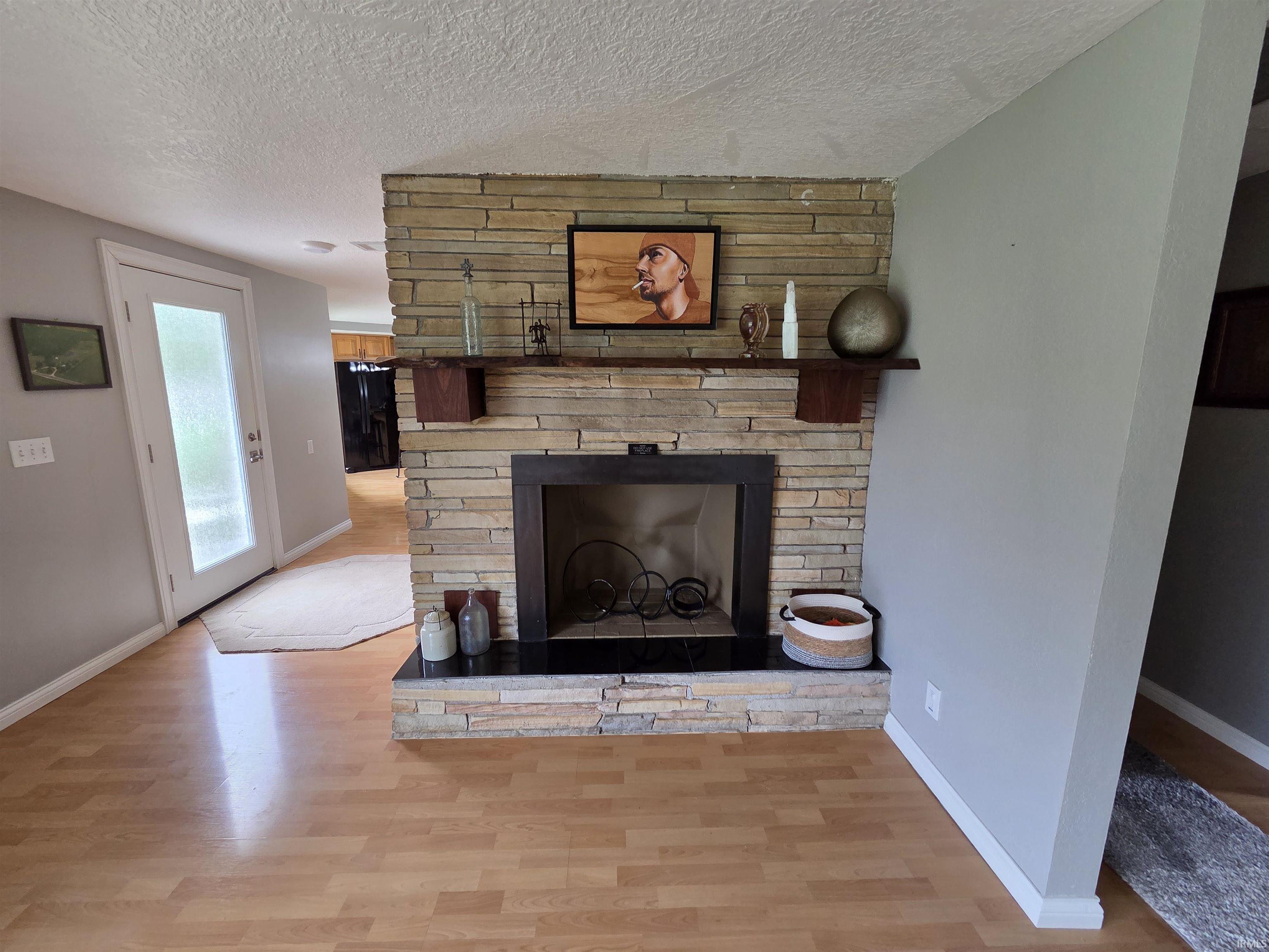 Stone-clad fireplace with a dark mantel shelf and black hearth