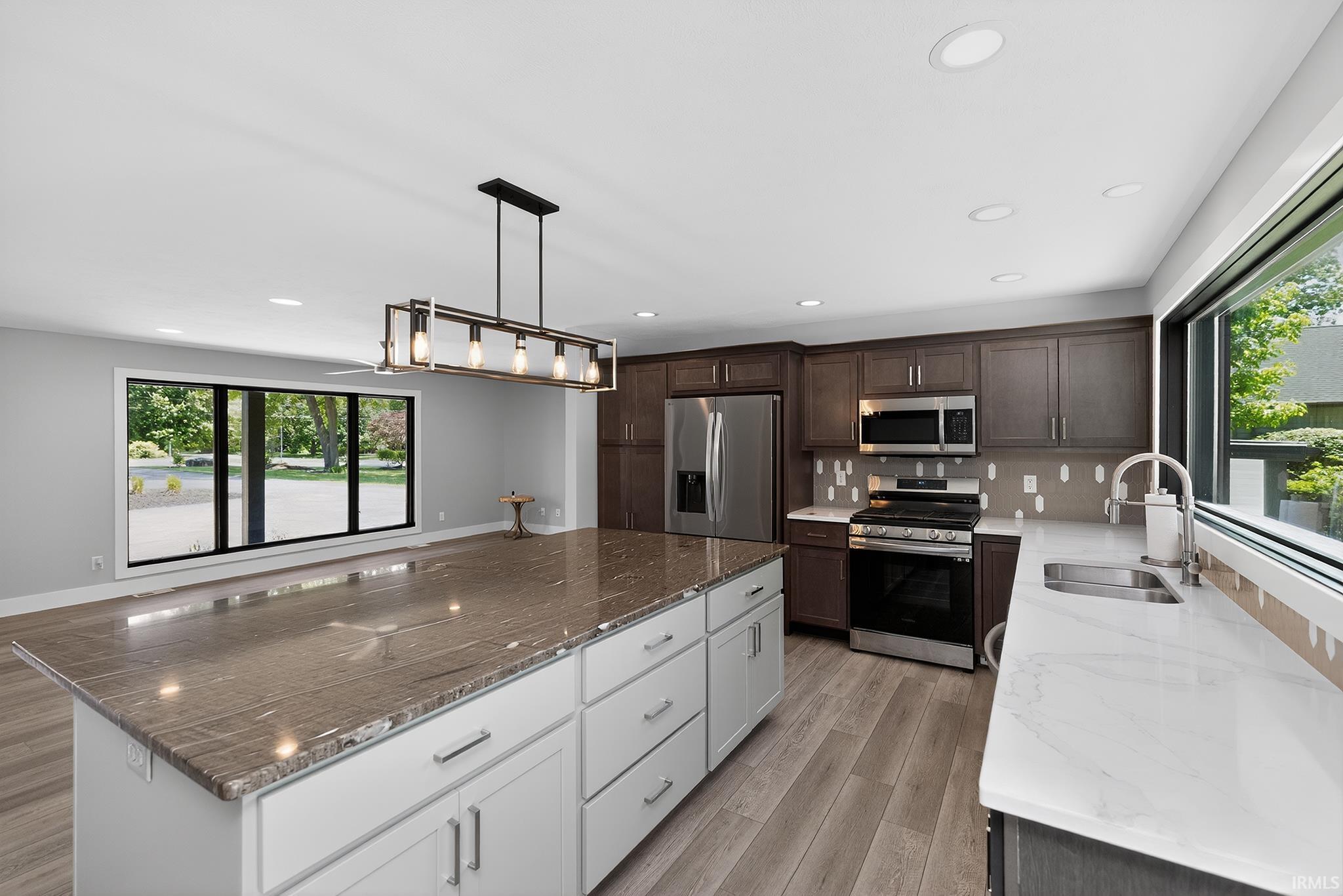 Expansive kitchen island with a stone countertop and white cabinetry