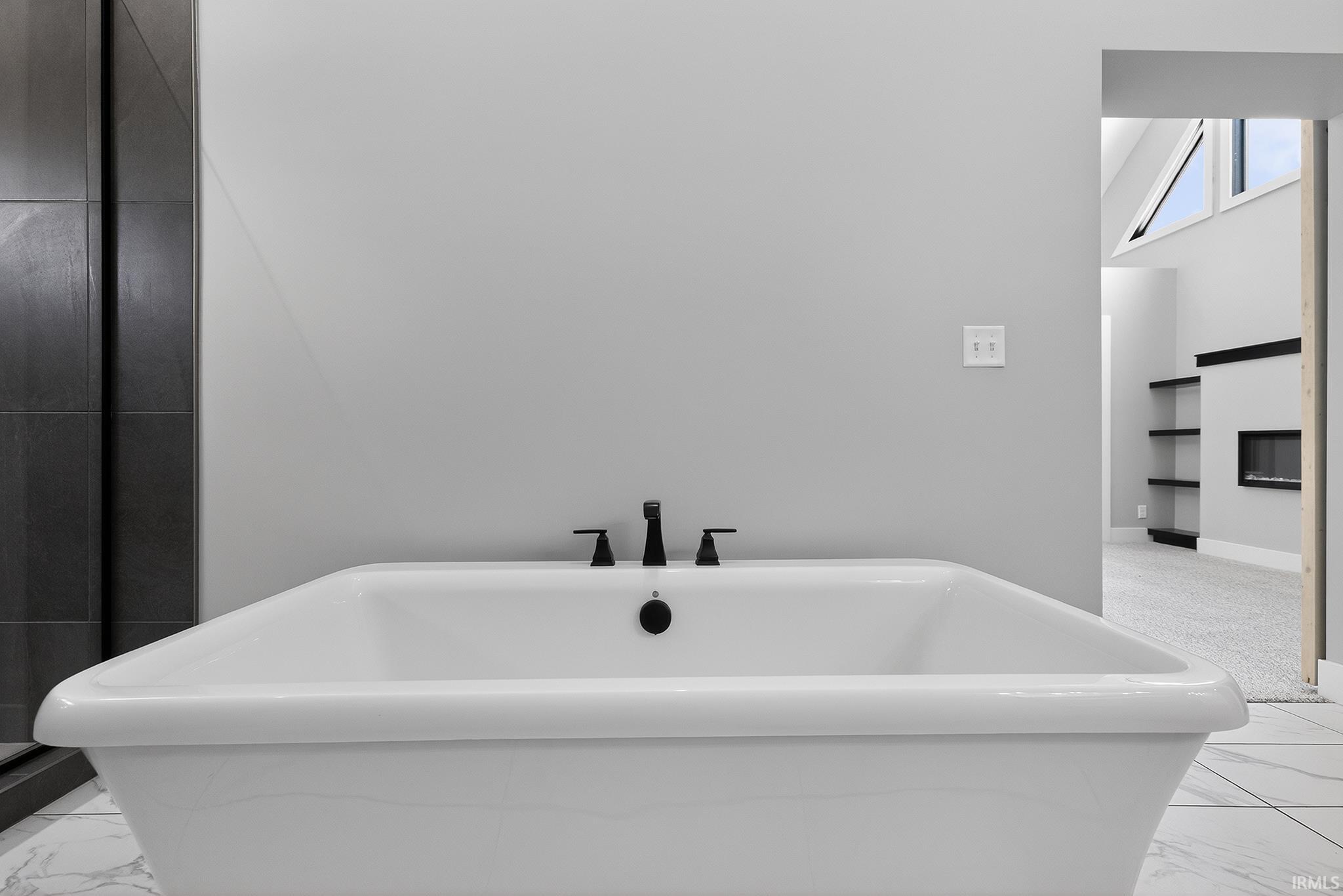 Freestanding soaking tub with matte black fixtures