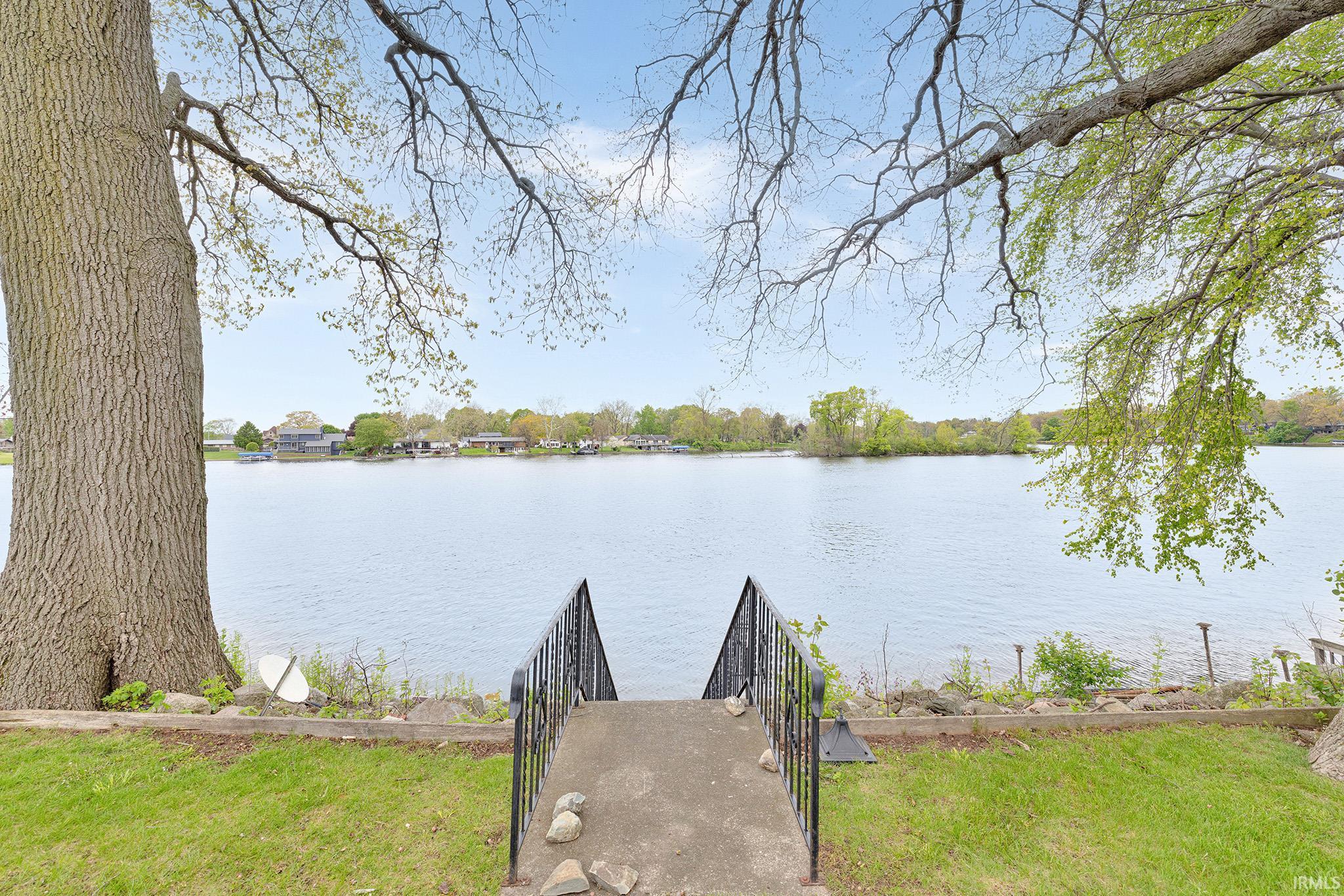 Concrete steps with wrought iron railings descending to a waterfront area