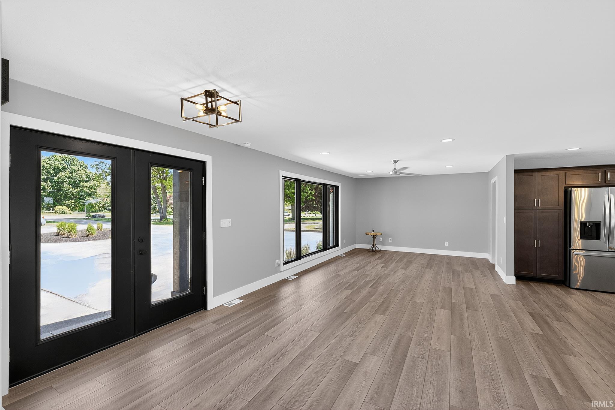 Spacious interior with wood-finish flooring, light gray walls, and recessed lighting