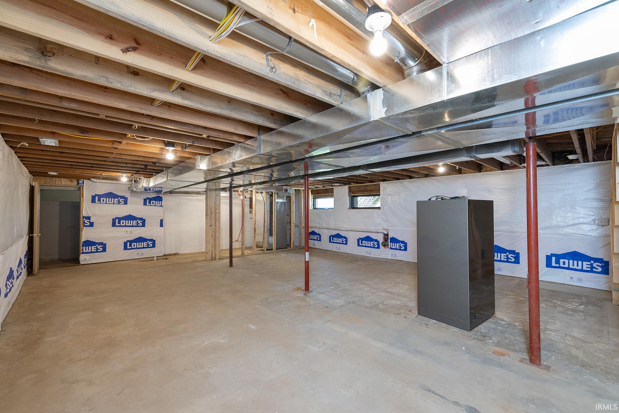 Unfinished basement offering exposed wood joists, concrete flooring, and visible ductwork