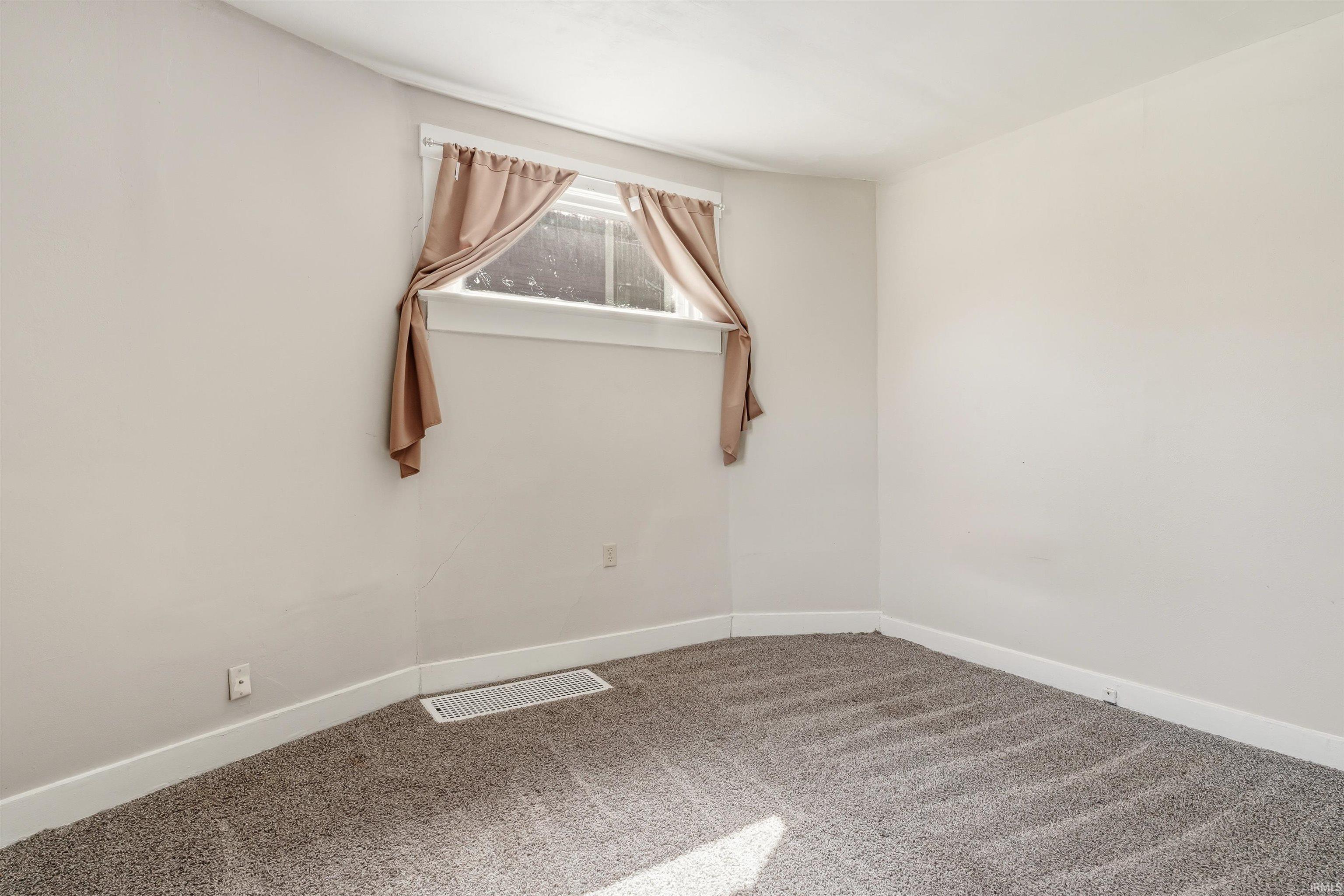 Room with light gray carpeting and white baseboards