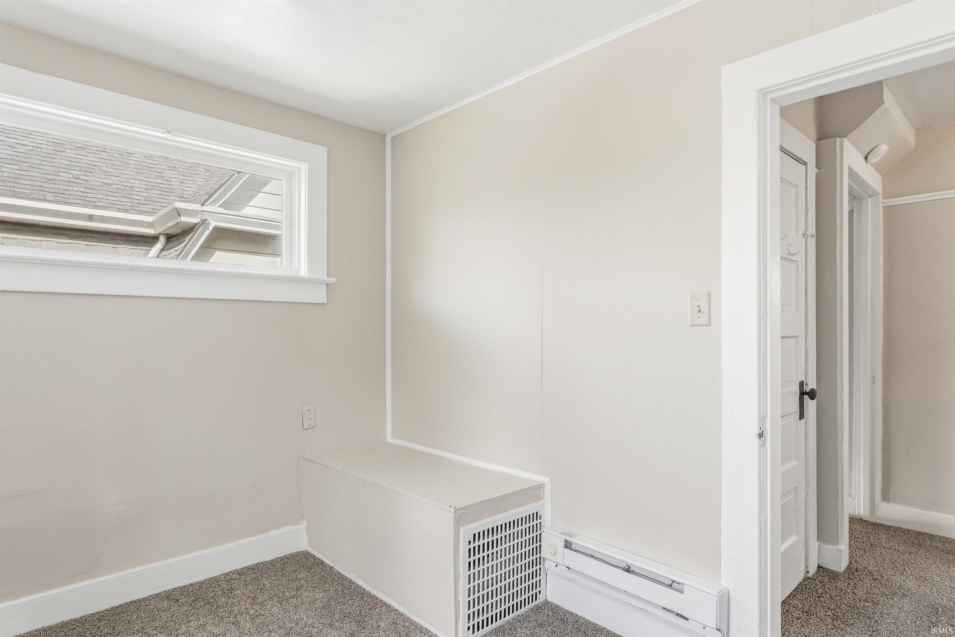 Neutral-toned walls and trim complement the grey carpeted flooring