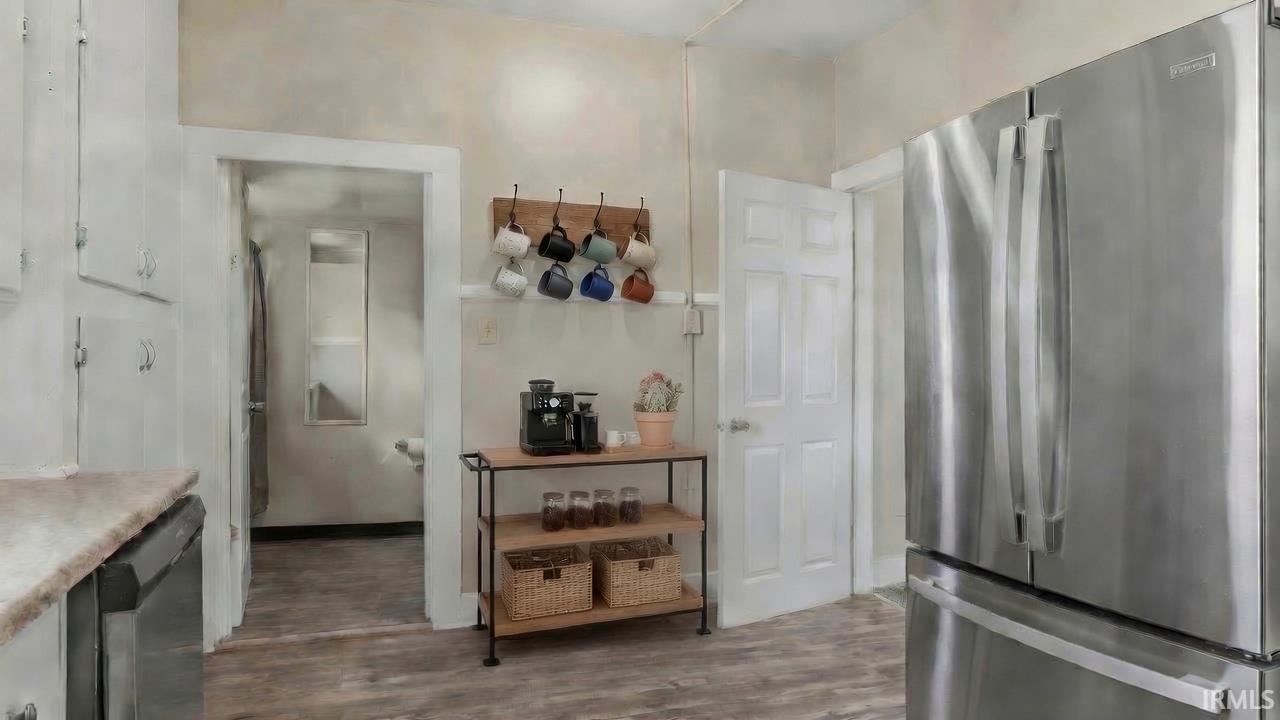 Kitchen with light wood-finish flooring and white cabinetry