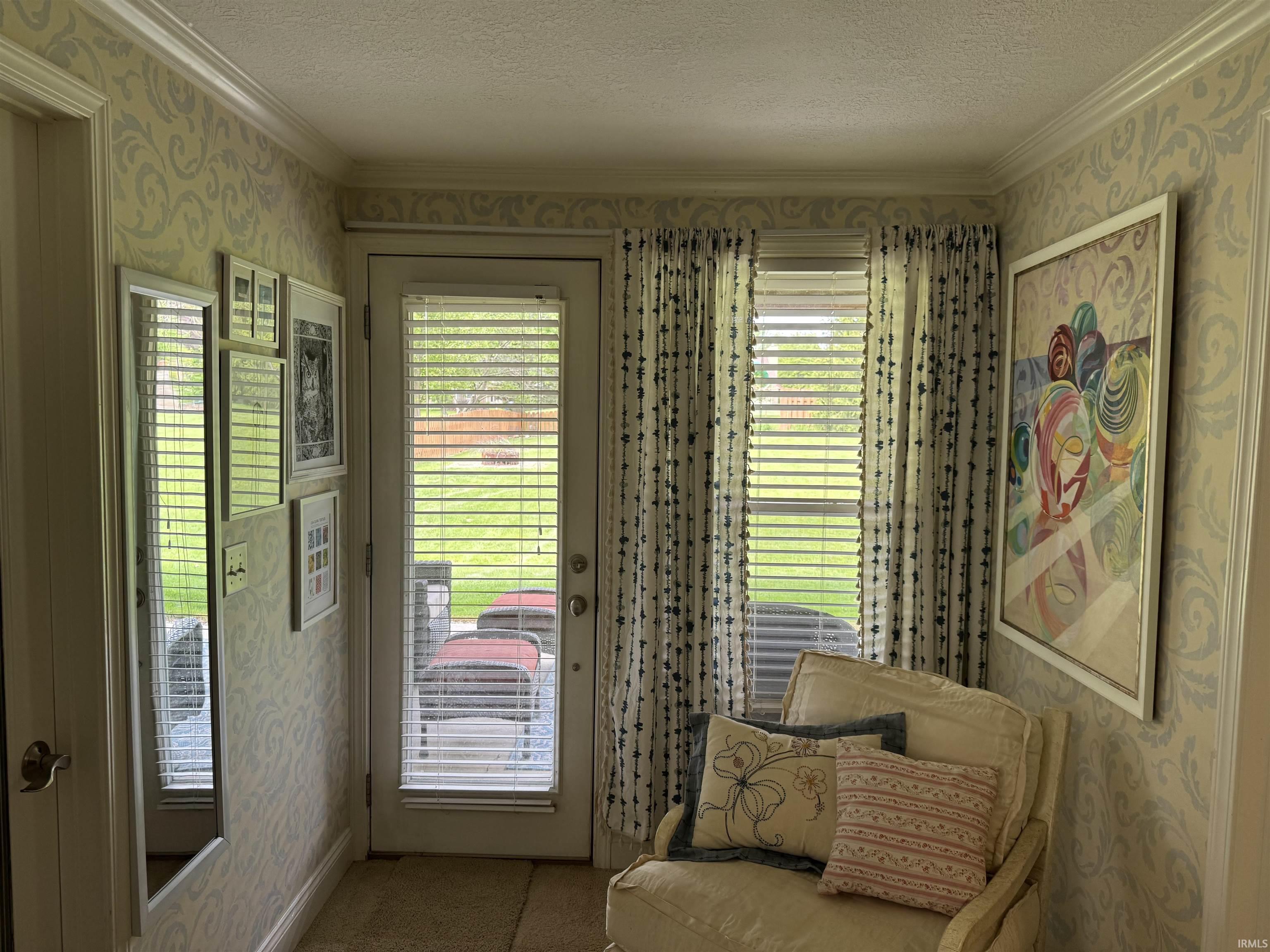 Carpeted interior area with a full-light exterior door featuring integrated blinds