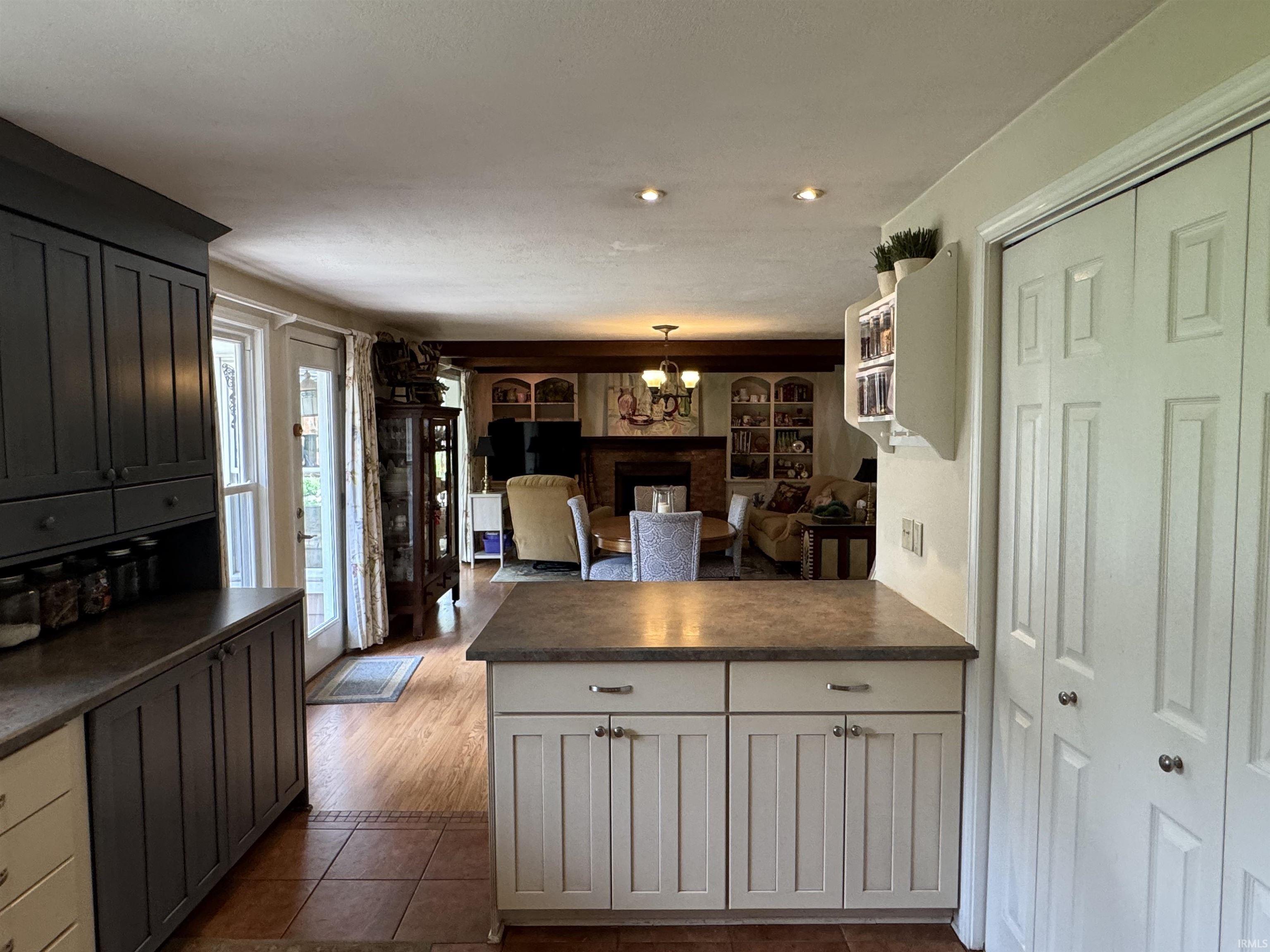 Kitchen with two-tone cabinetry, a peninsula with countertop space, and bifold pantry doors