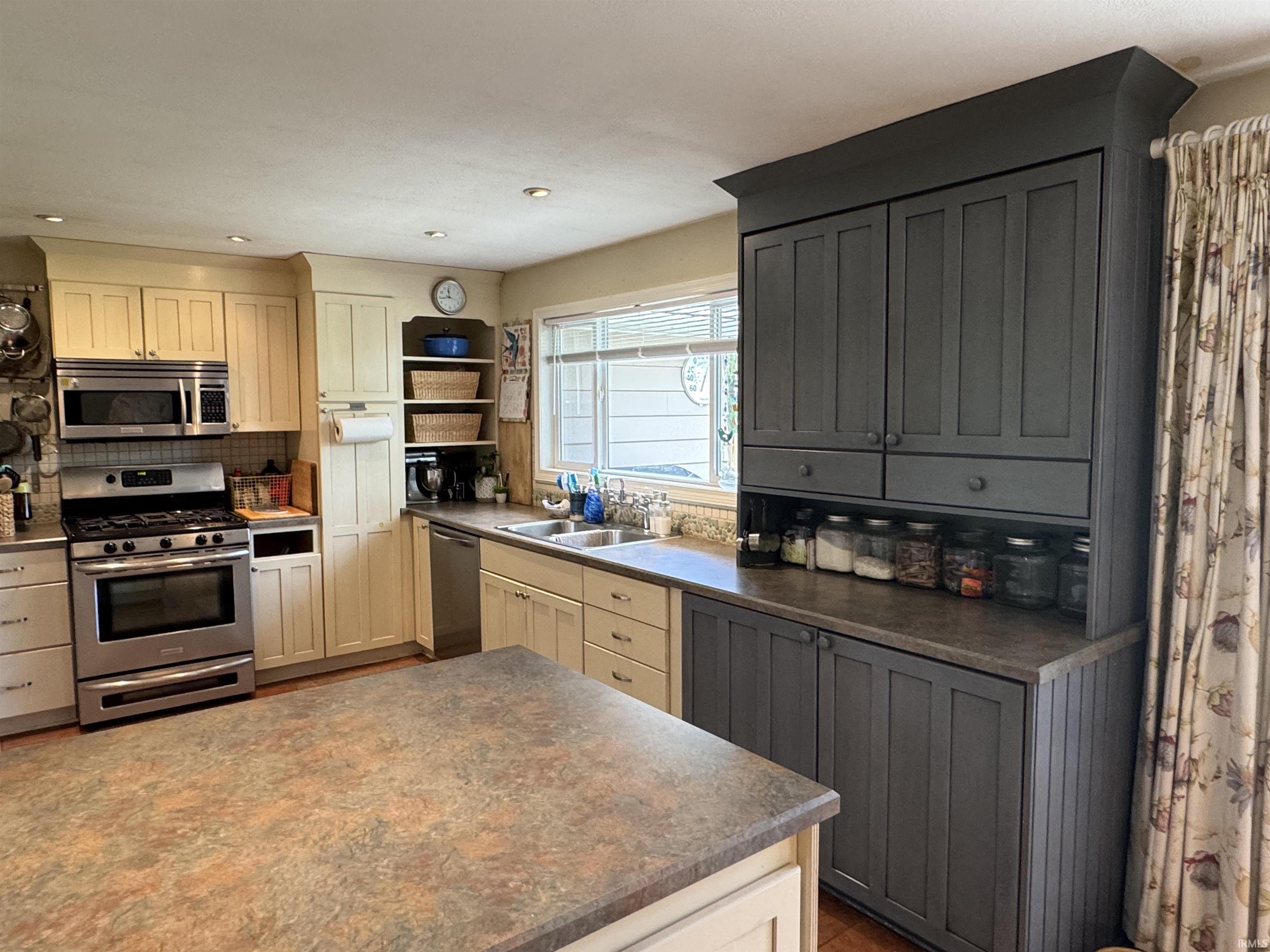 Kitchen featuring a dual-tone cabinetry scheme with cream-painted uppers and charcoal-painted lower and built-in units