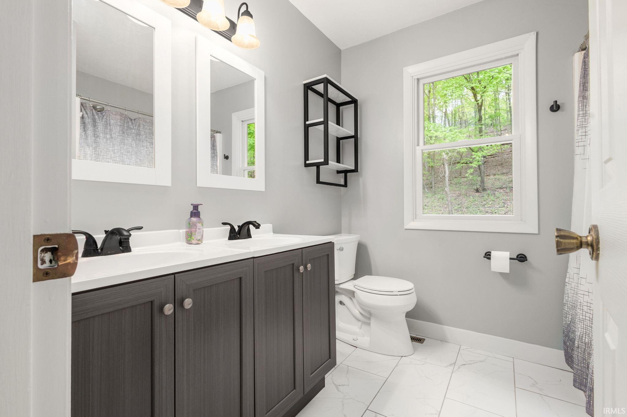 Dual vanity with a white countertop and dark wood-finish cabinetry