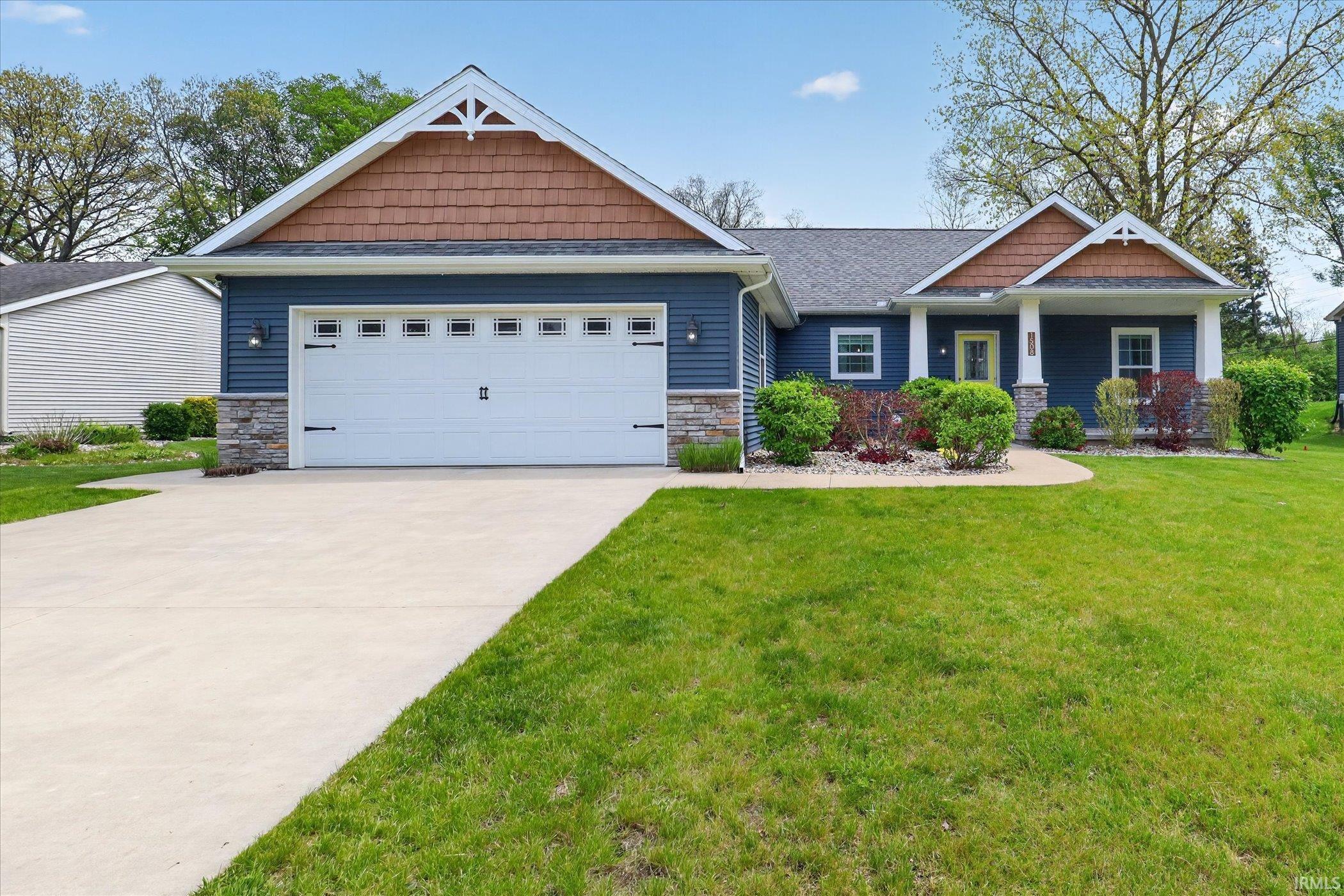 Craftsman-style home featuring blue siding, stone accents, and cedar shake gables