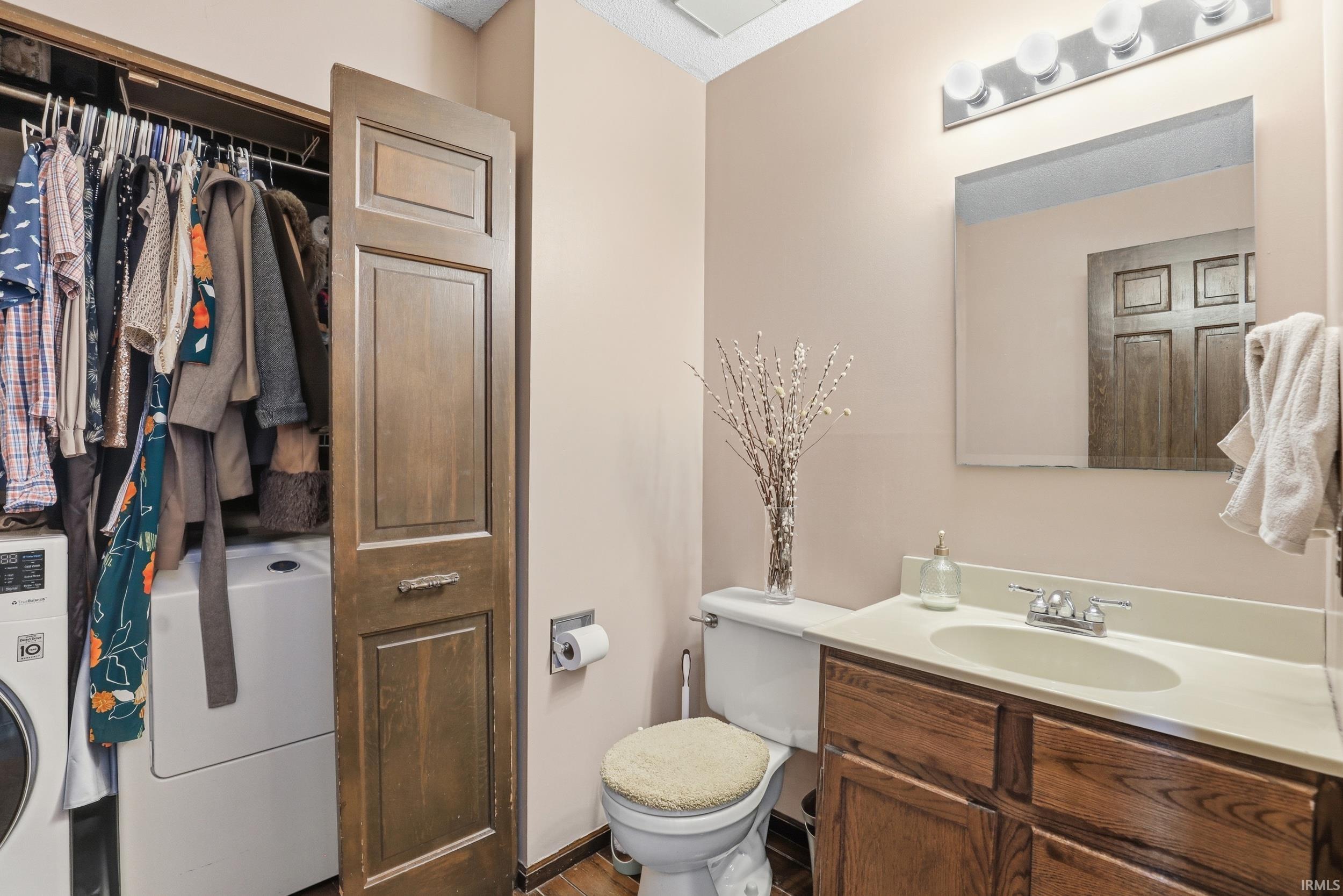Full-size stacked washer and dryer in a dedicated closet with bi-fold doors