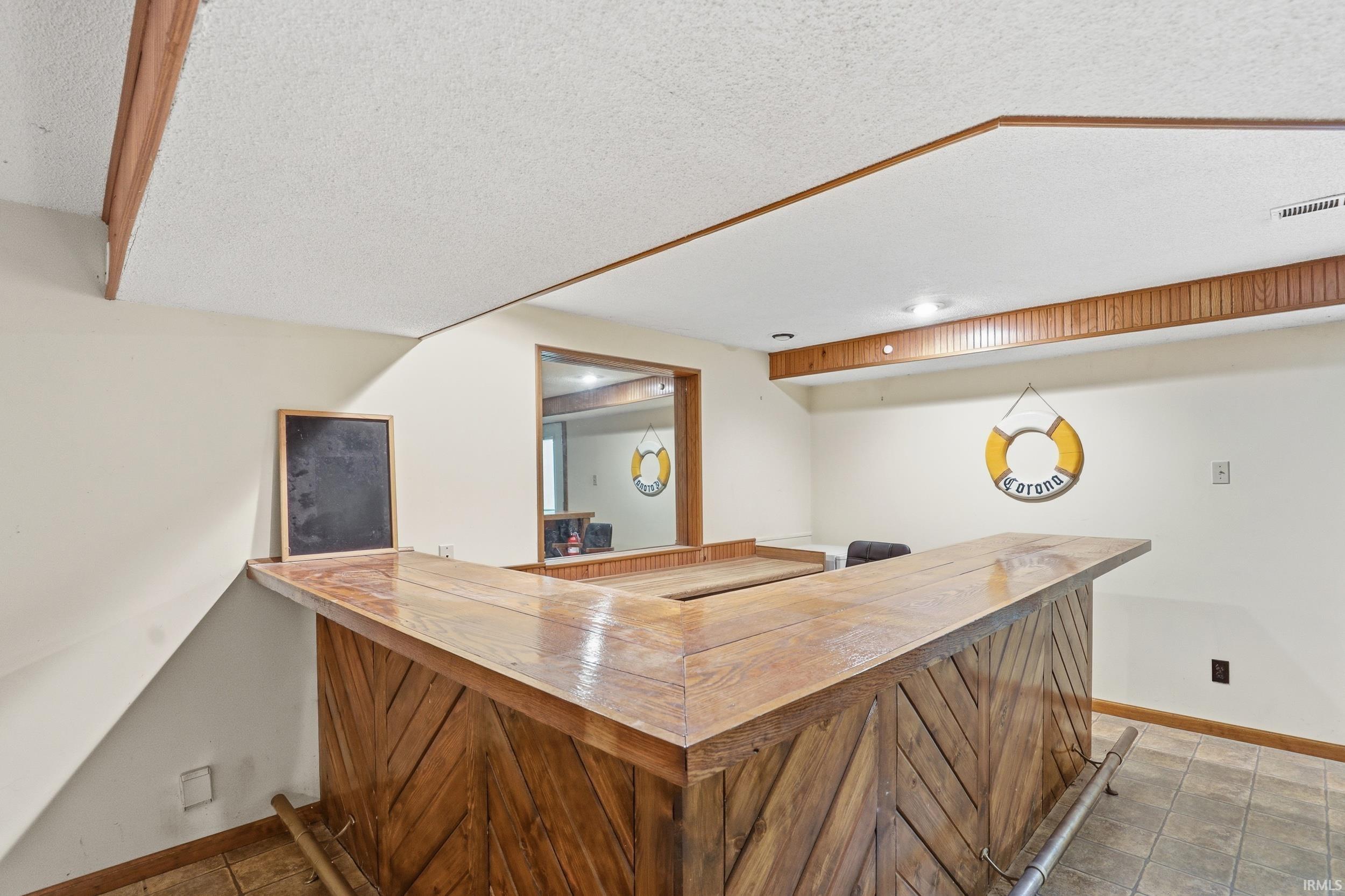 Custom-built wood bar featuring a footrail and a pass-through window