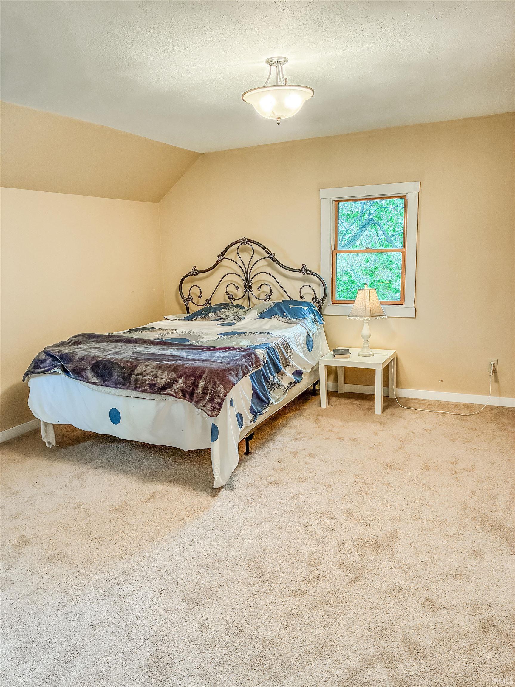 Carpeted room with a window featuring white trim