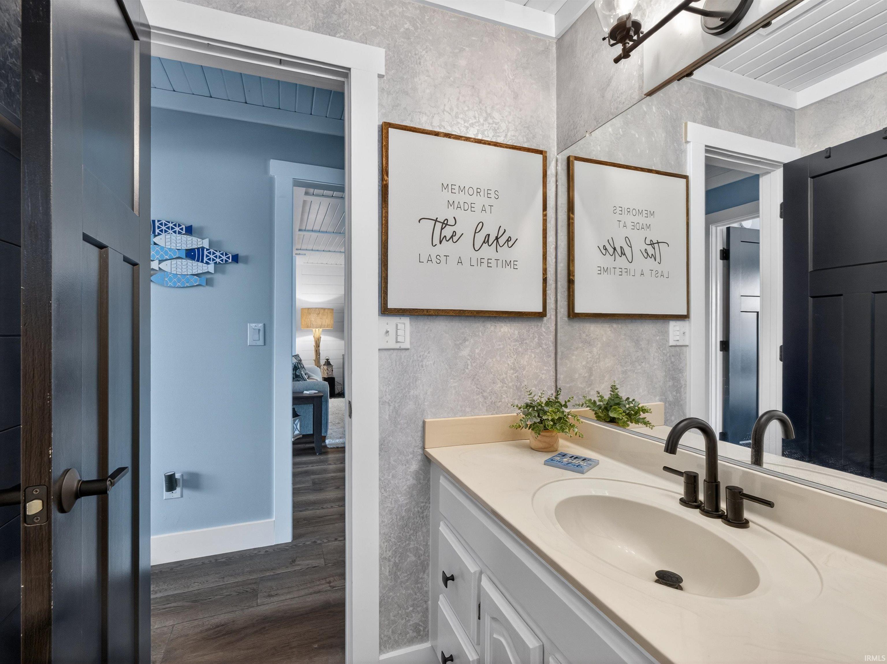 Bathroom vanity featuring a single basin, dark bronze faucet, and light-toned countertop