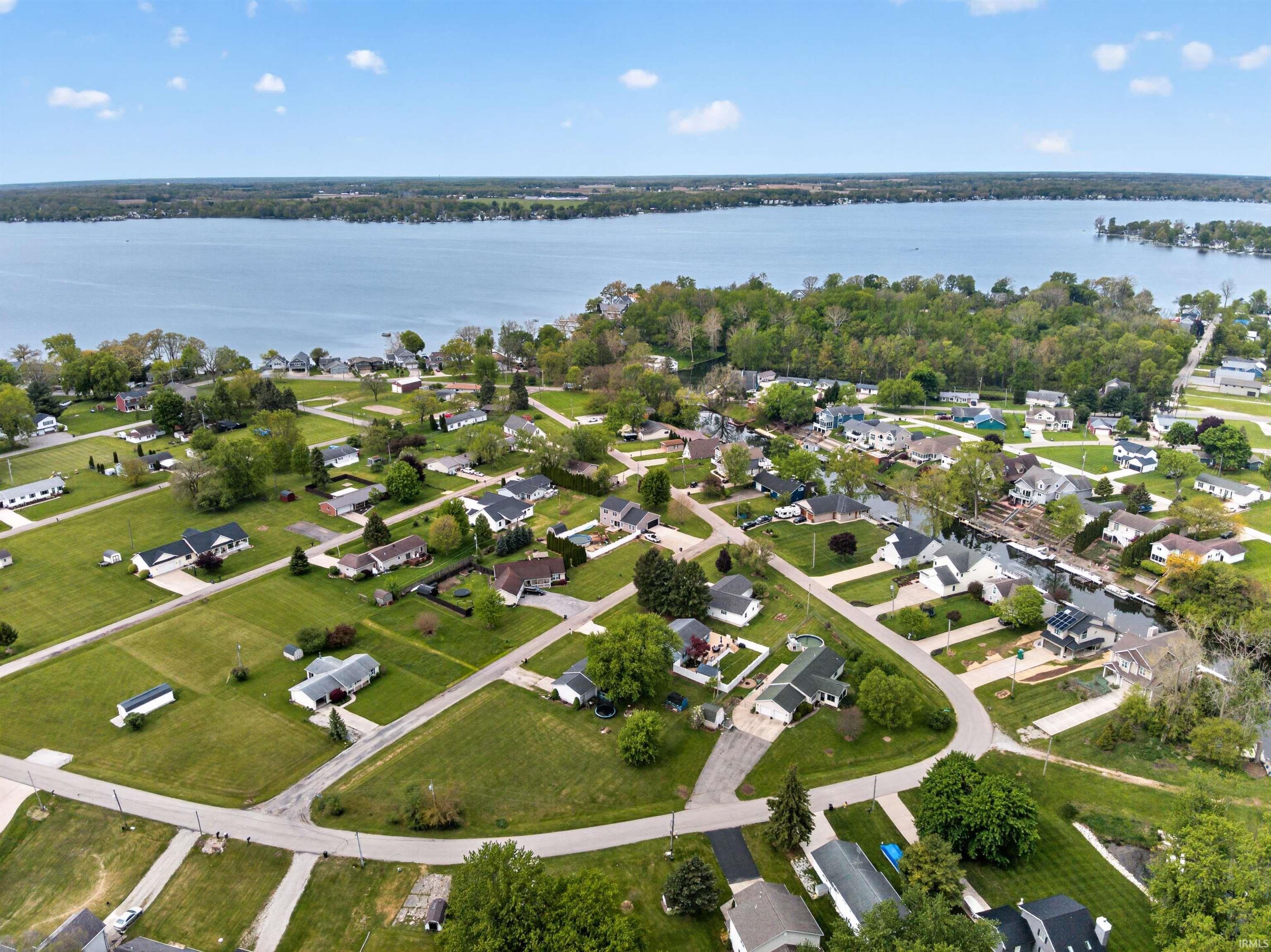 Aerial depiction of a residential neighborhood with properties featuring green lawns and mature trees