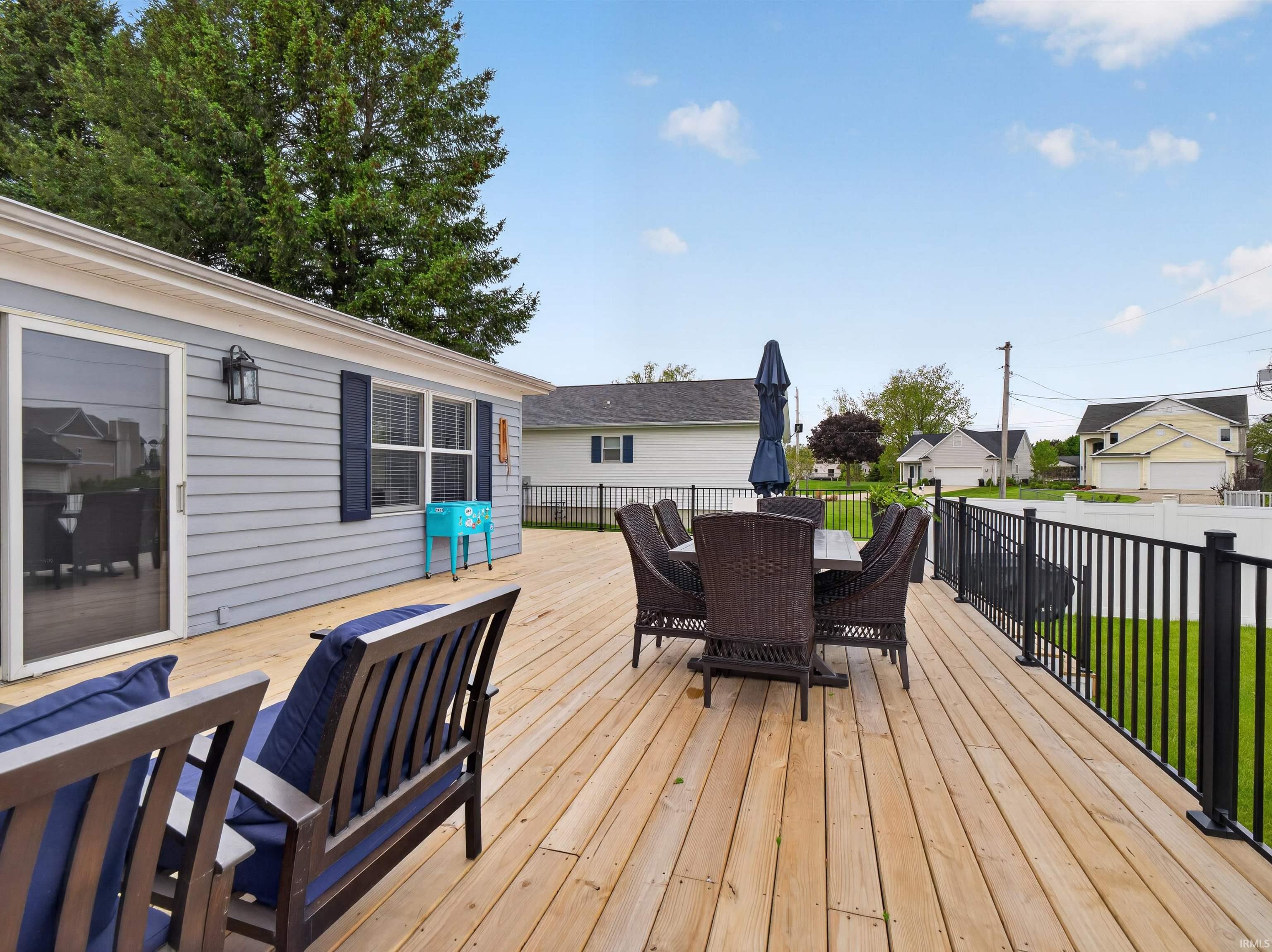 Expansive wood deck with black metal railing, offering ample outdoor living space
