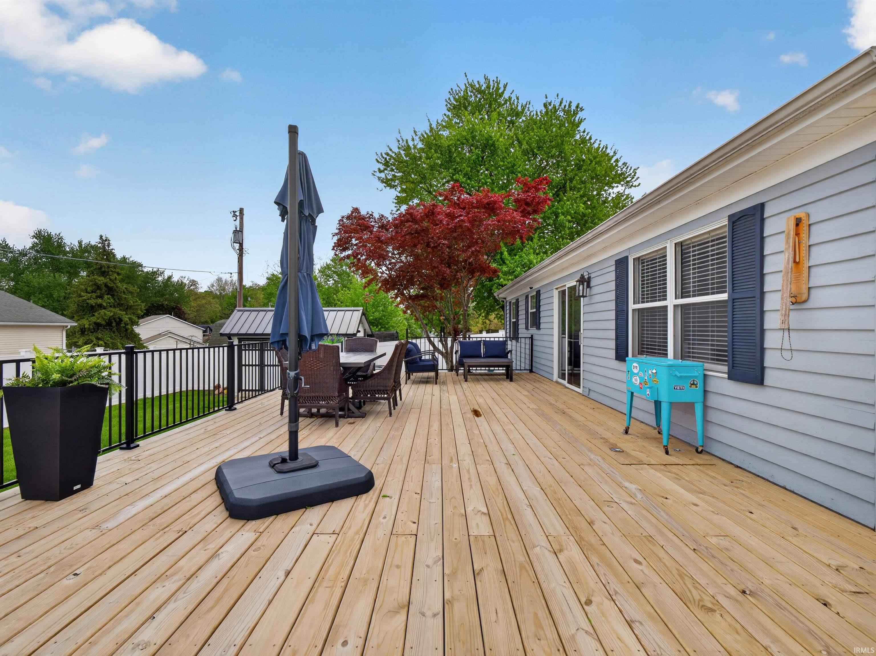 Expansive wood-finish deck with black metal railing