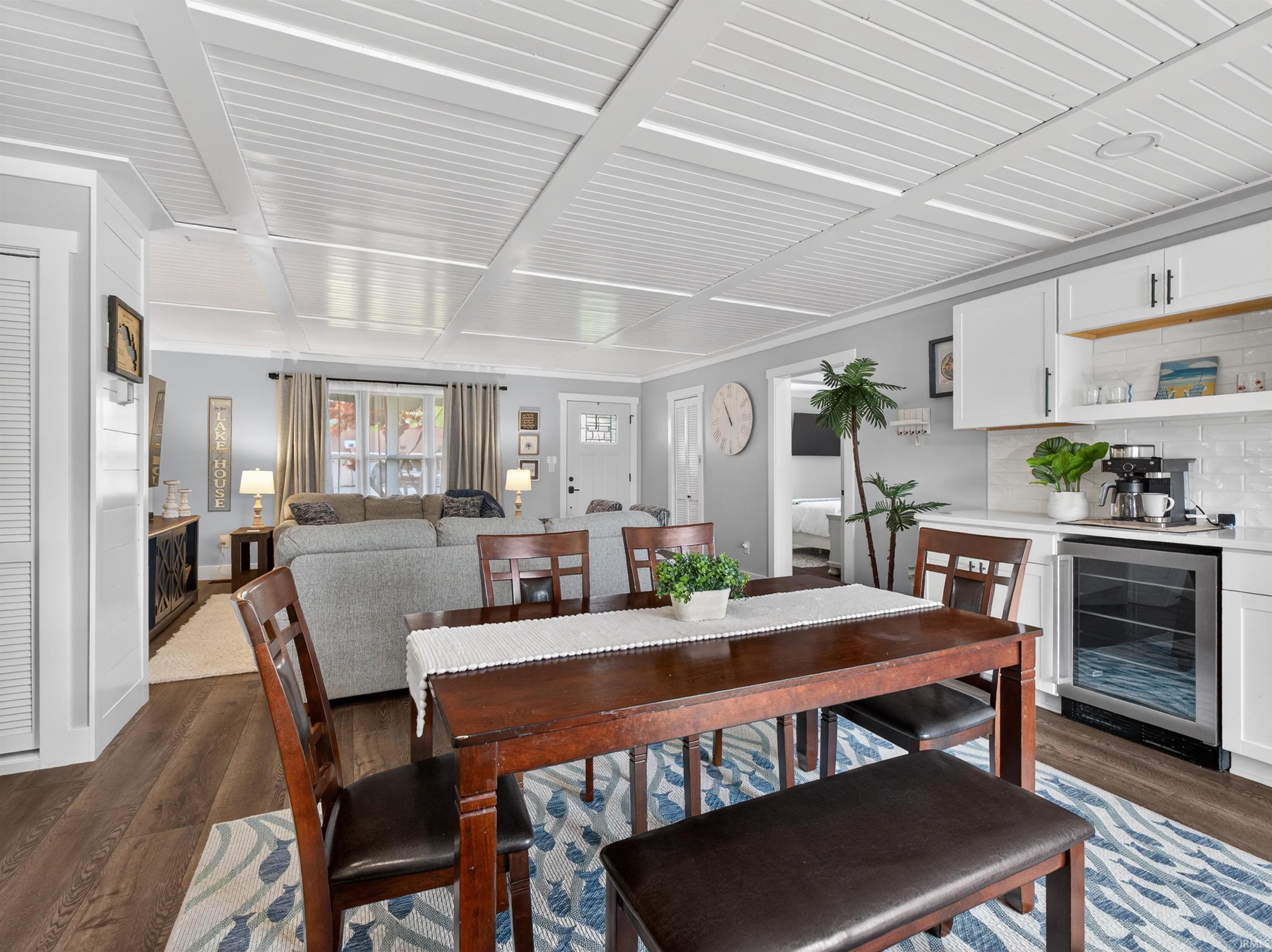Open-concept living area featuring a coffered ceiling, wood-finish flooring, and light gray walls