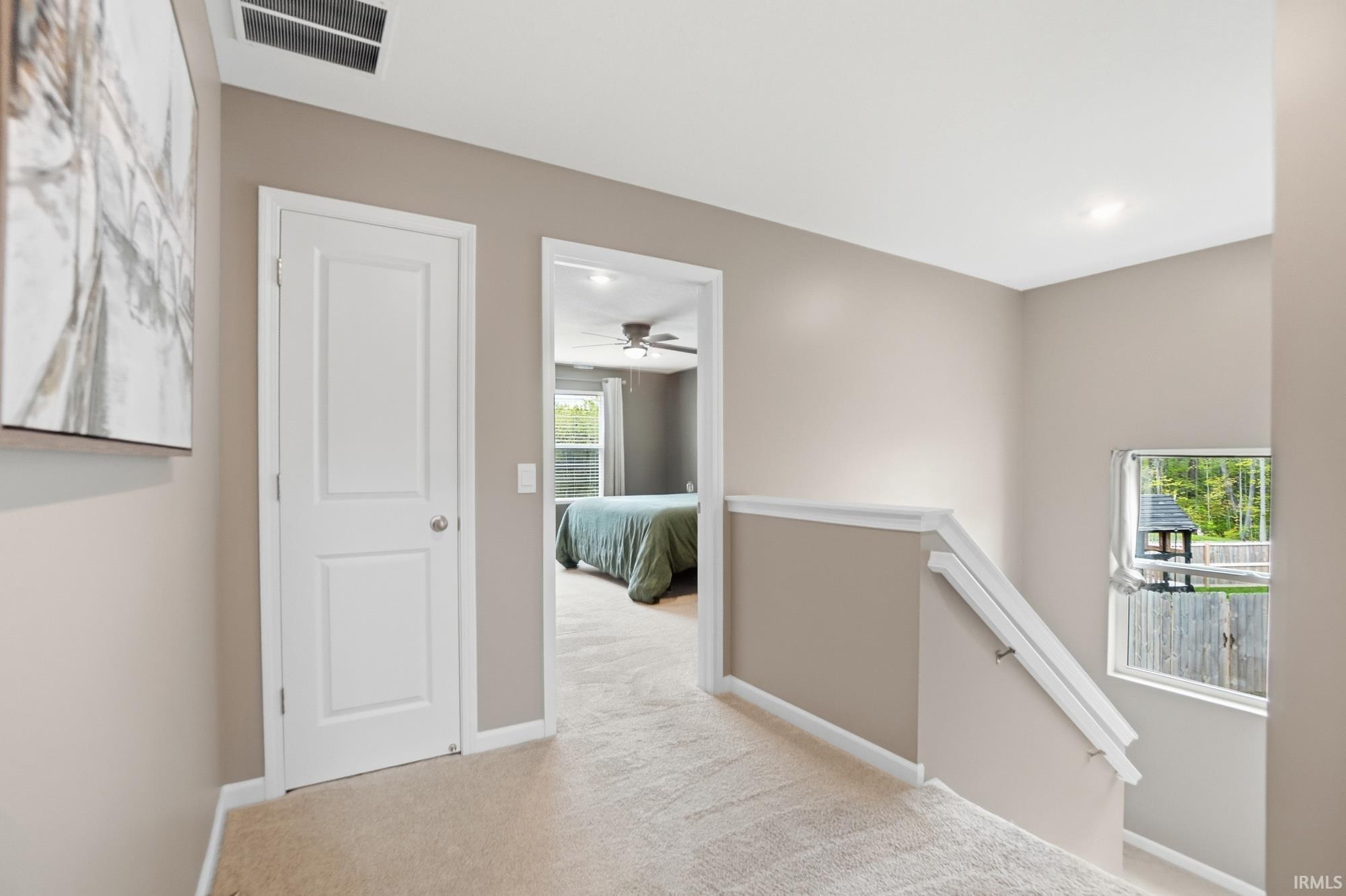 Upper-level hallway with neutral wall tones and plush carpeting