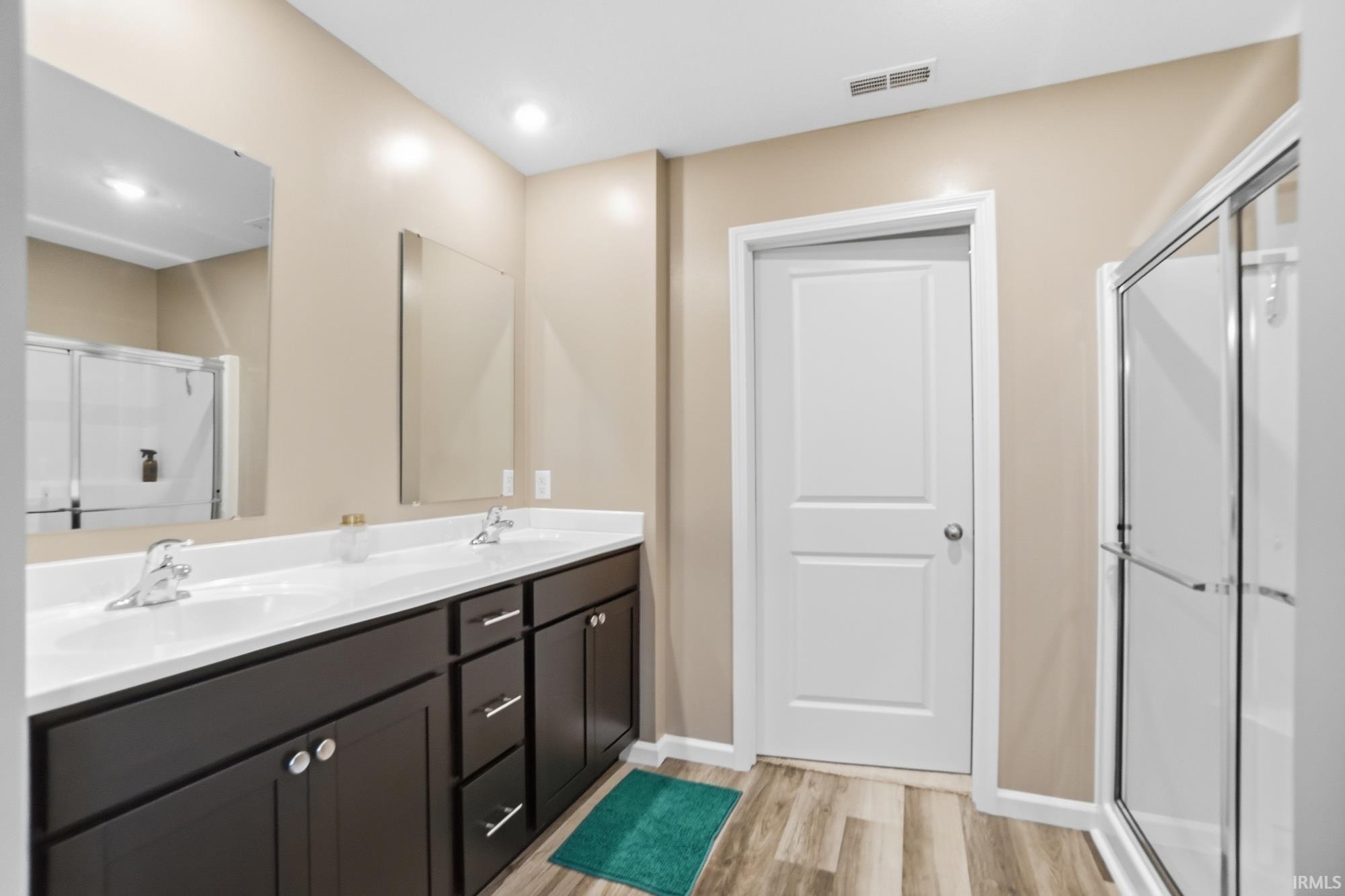Double vanity with white countertops, undermount sinks, and chrome faucets