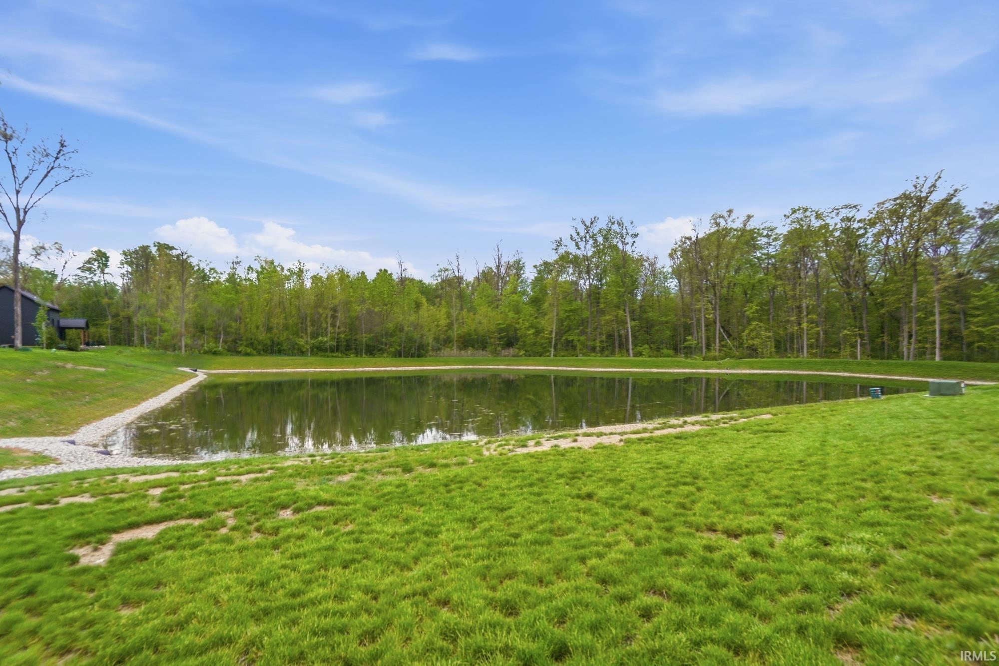 Expansive green space featuring a large pond