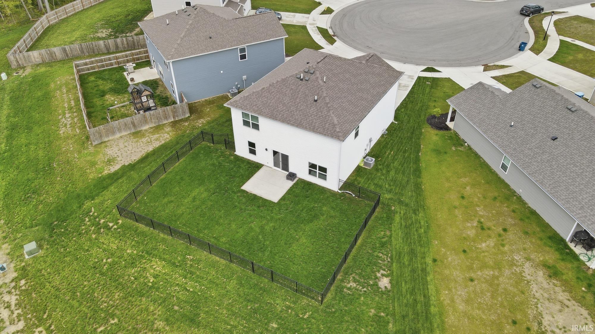 Rear exterior featuring a fenced yard, concrete patio, and white siding