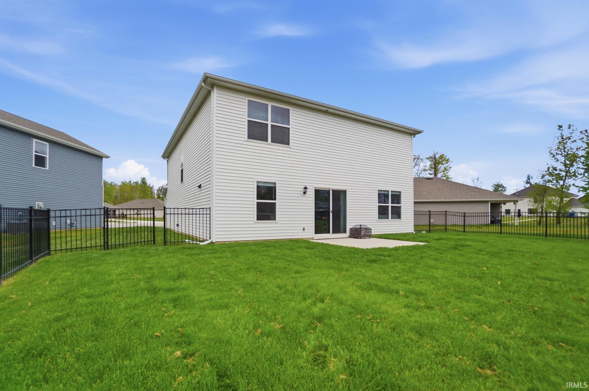 Expansive green lawn featuring a black metal fence