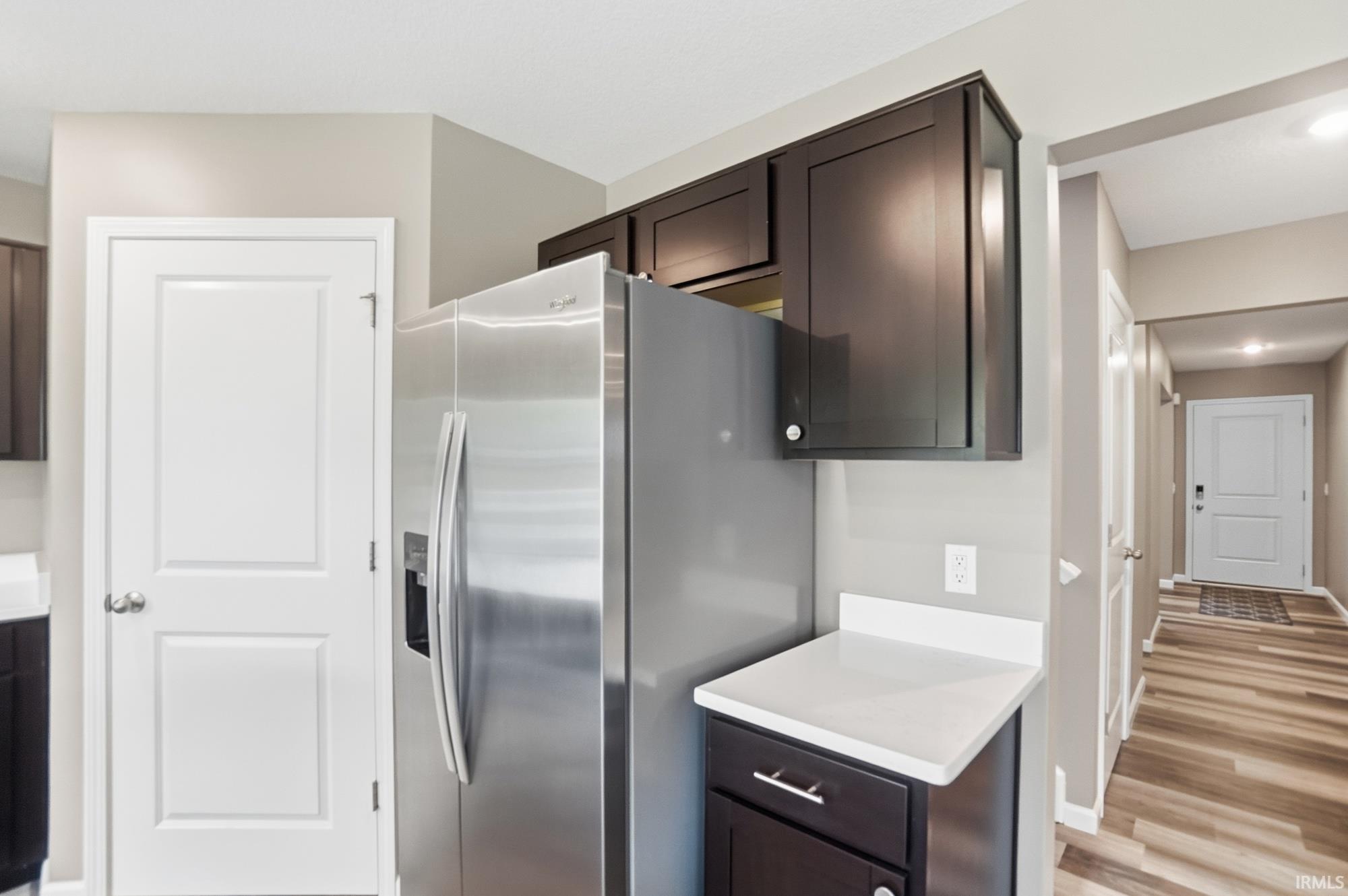 Stainless steel refrigerator integrated with dark wood-finish cabinetry