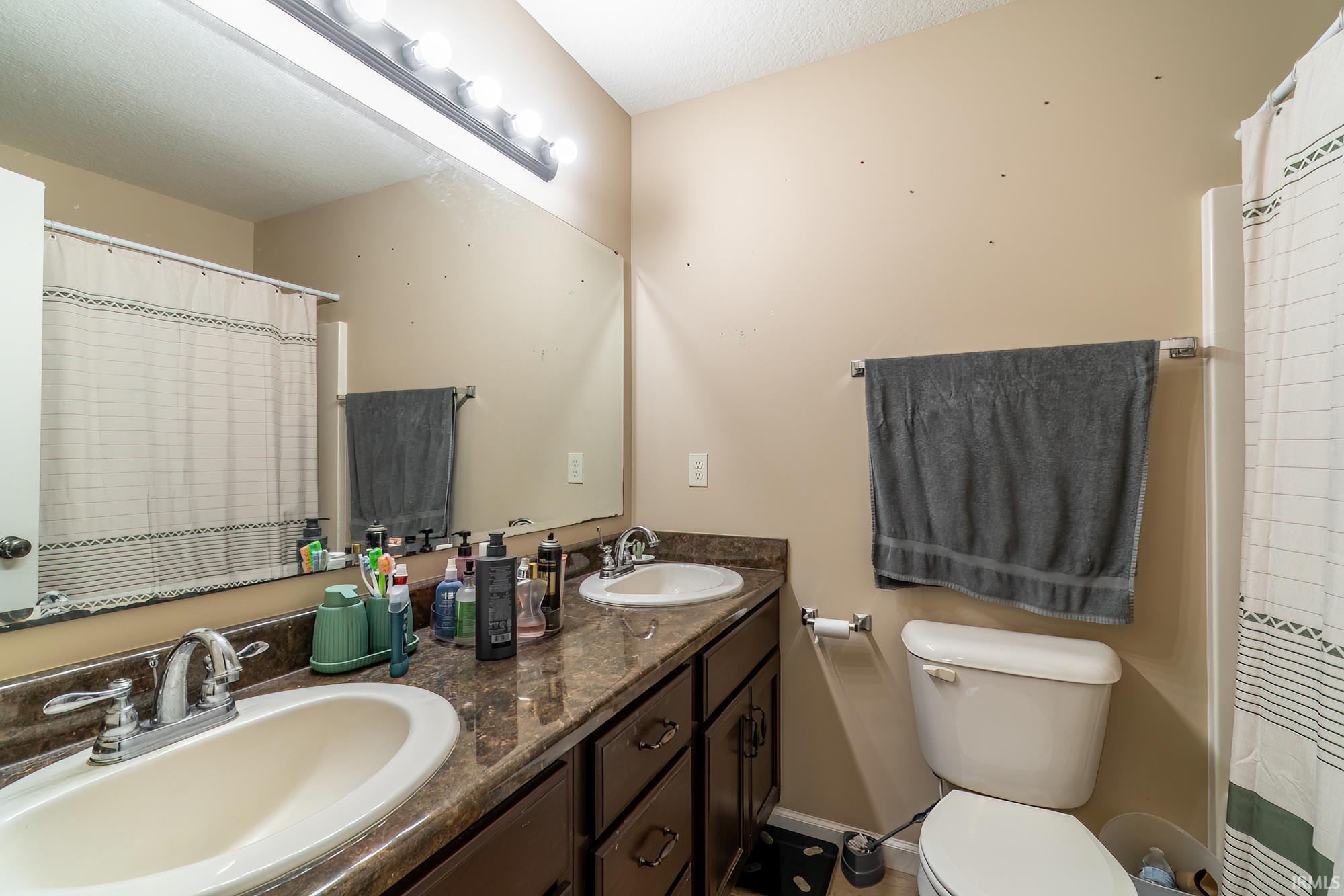Double vanity with white oval undermount sinks, chrome faucets, and a speckled brown countertop