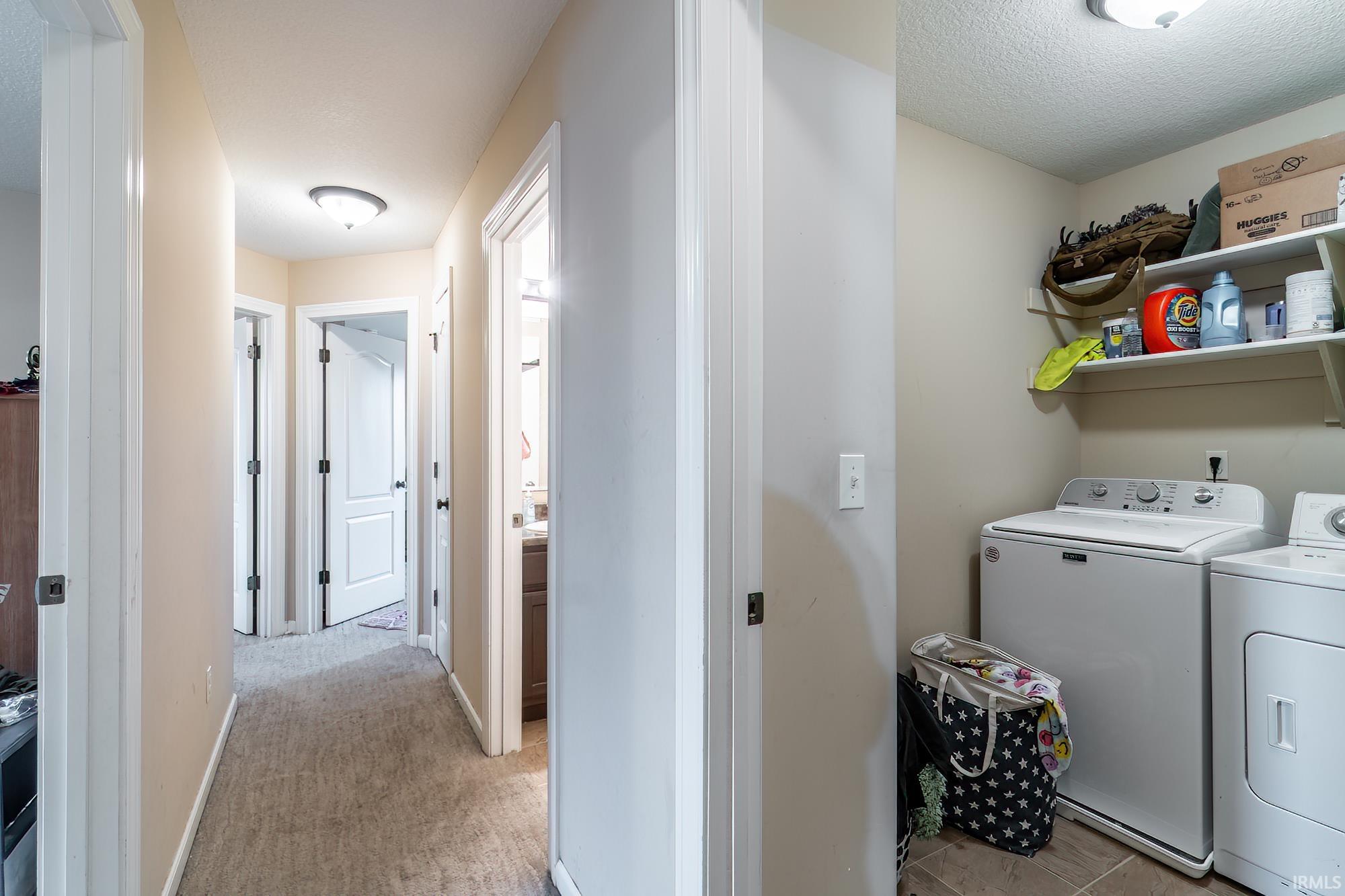 Dedicated laundry area featuring shelving and tile flooring