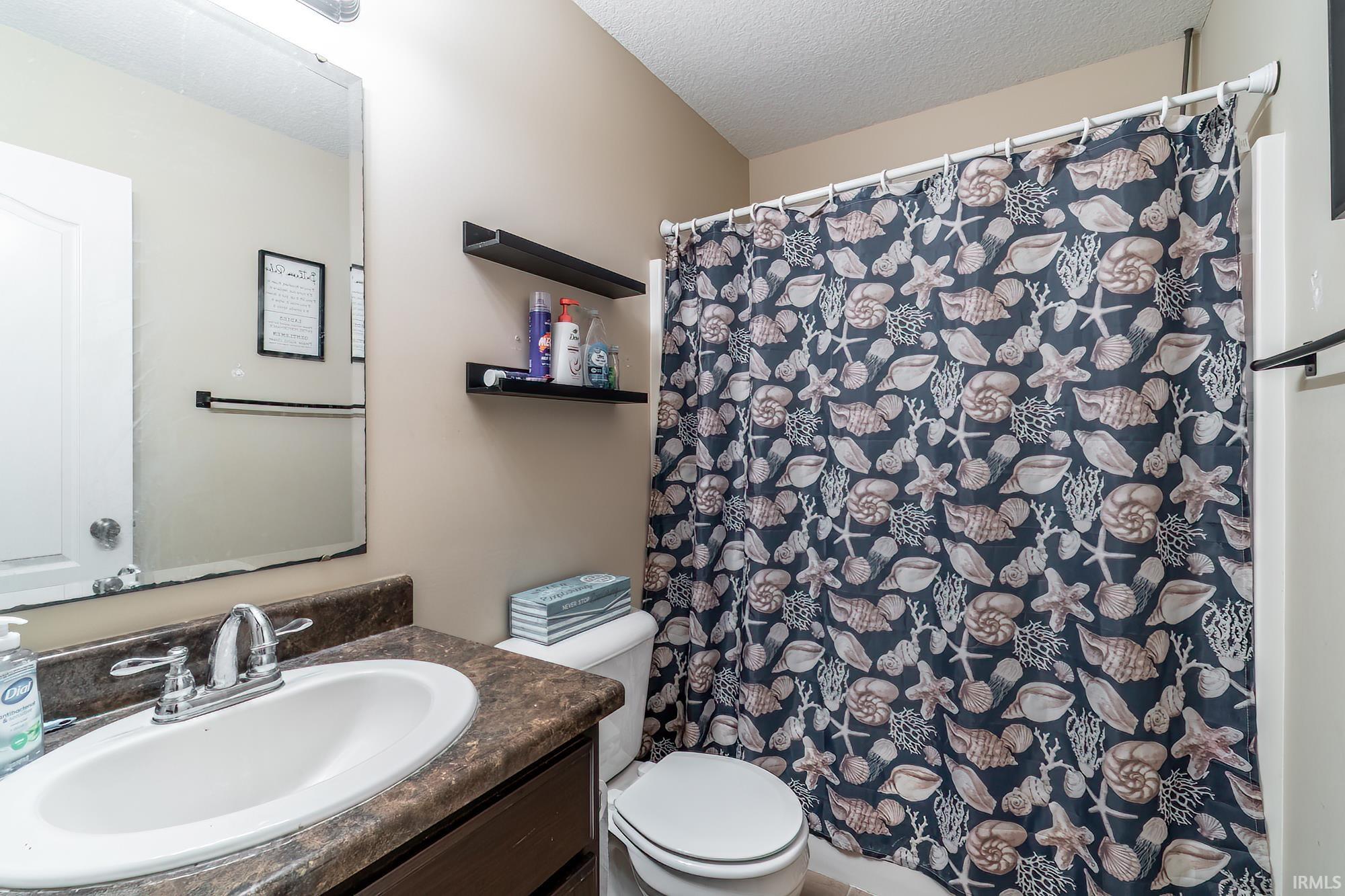 Full bathroom featuring a vanity with an integrated sink, chrome faucet, and a large wall-mounted mirror
