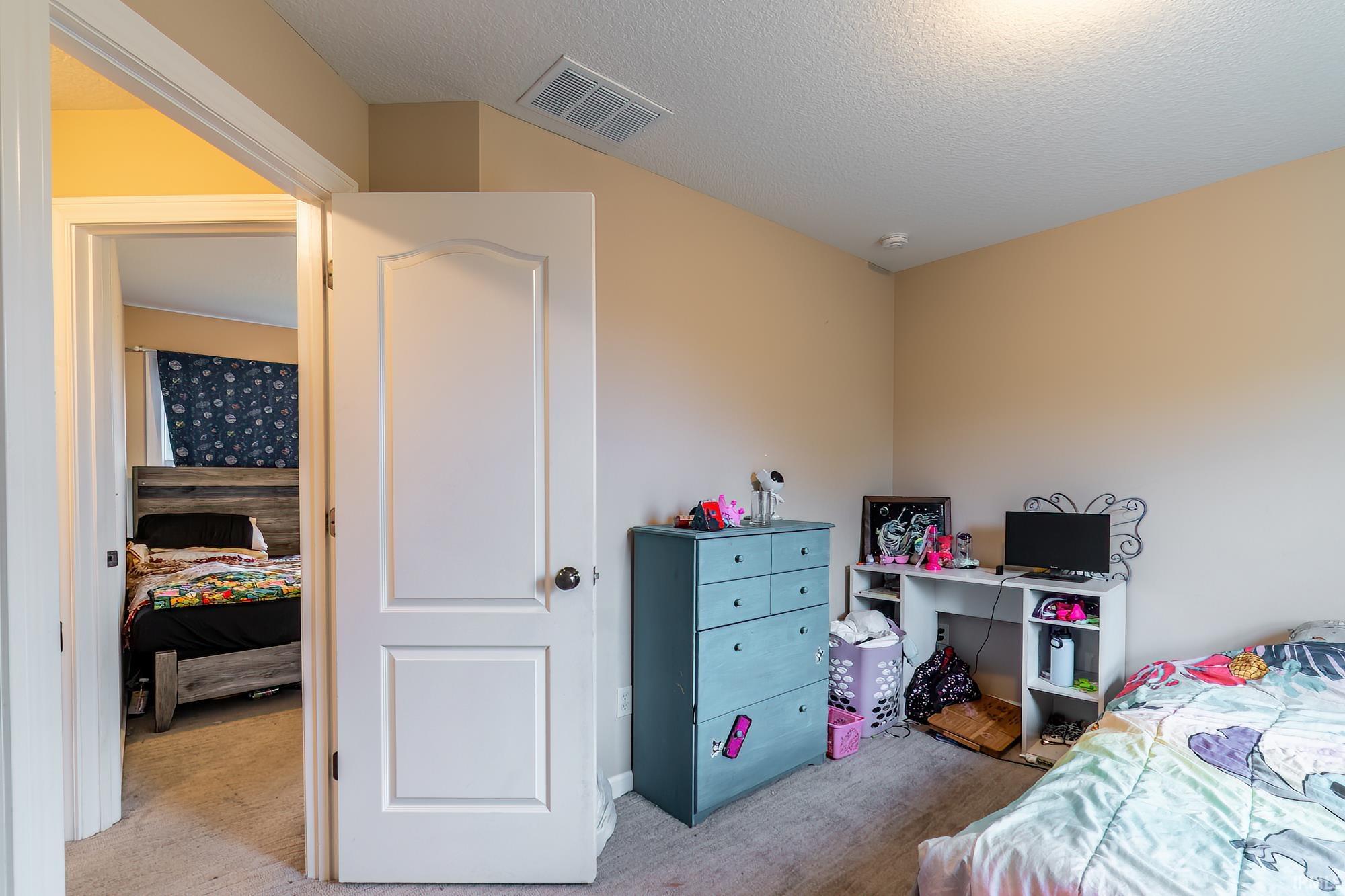 Interior room featuring warm-toned walls and neutral carpet flooring