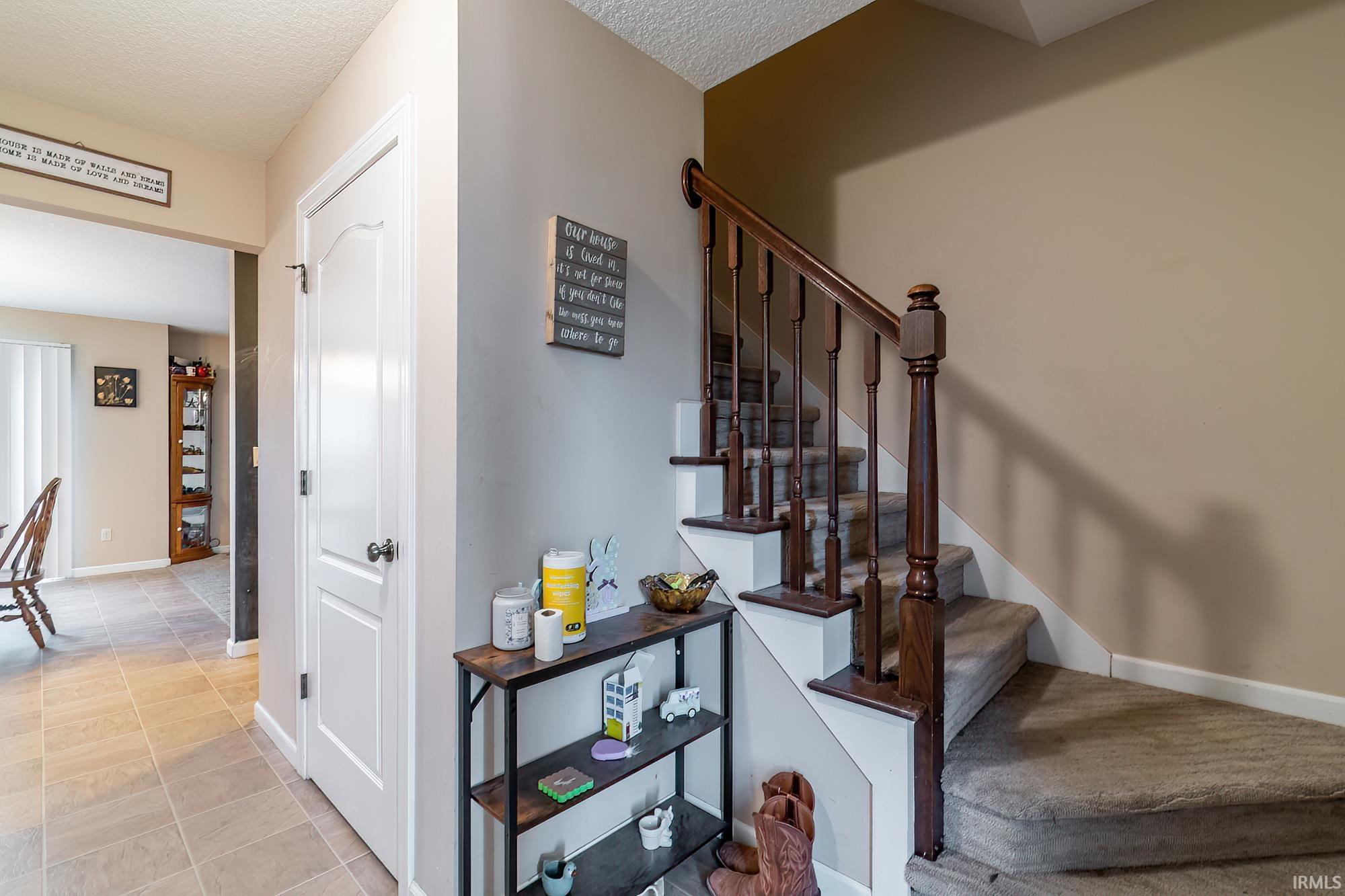 Staircase featuring dark wood newel posts and balusters, carpeted treads, and a white stringer