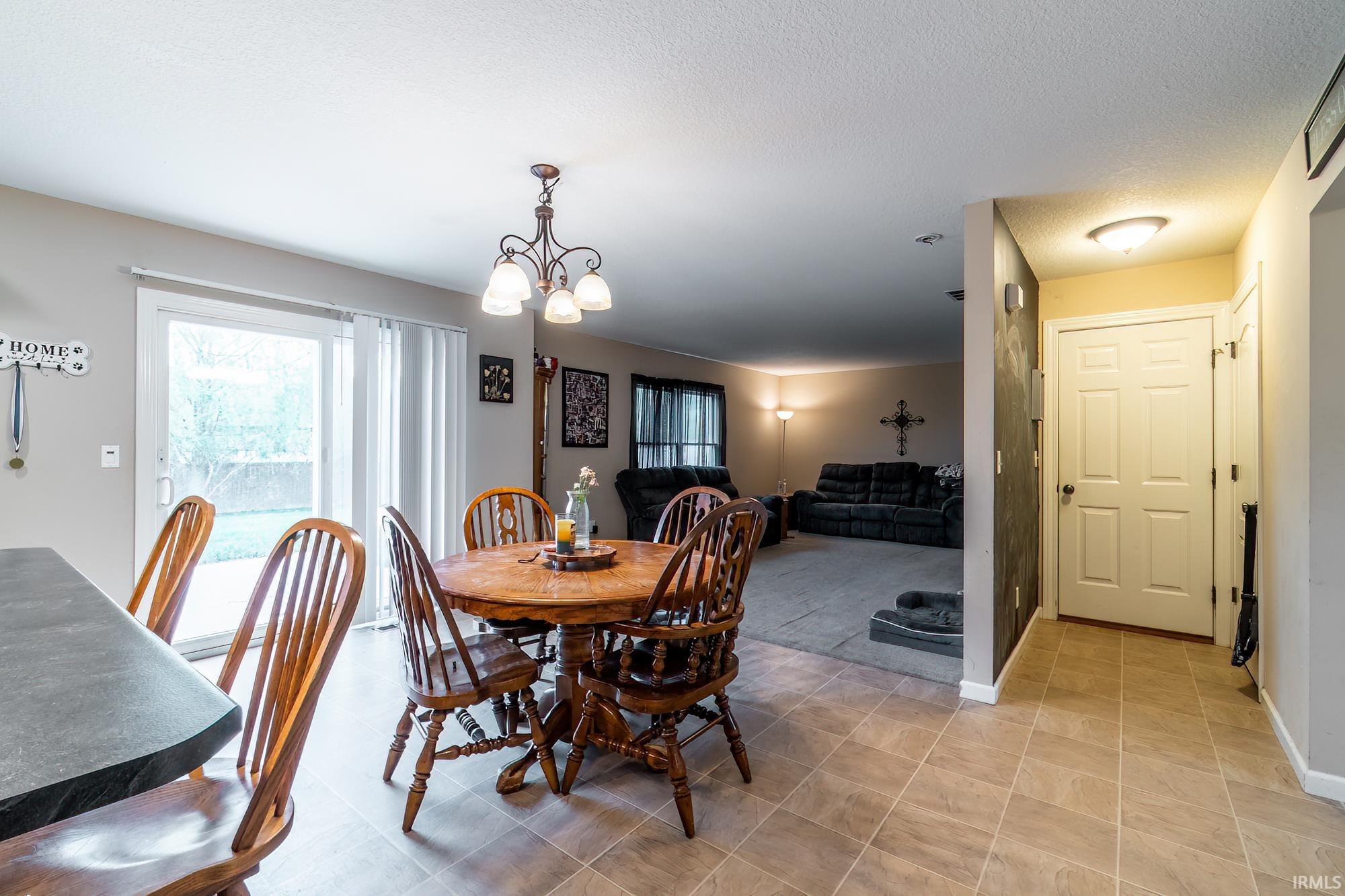 Dining area with ceramic tile flooring and a bronze chandelier
