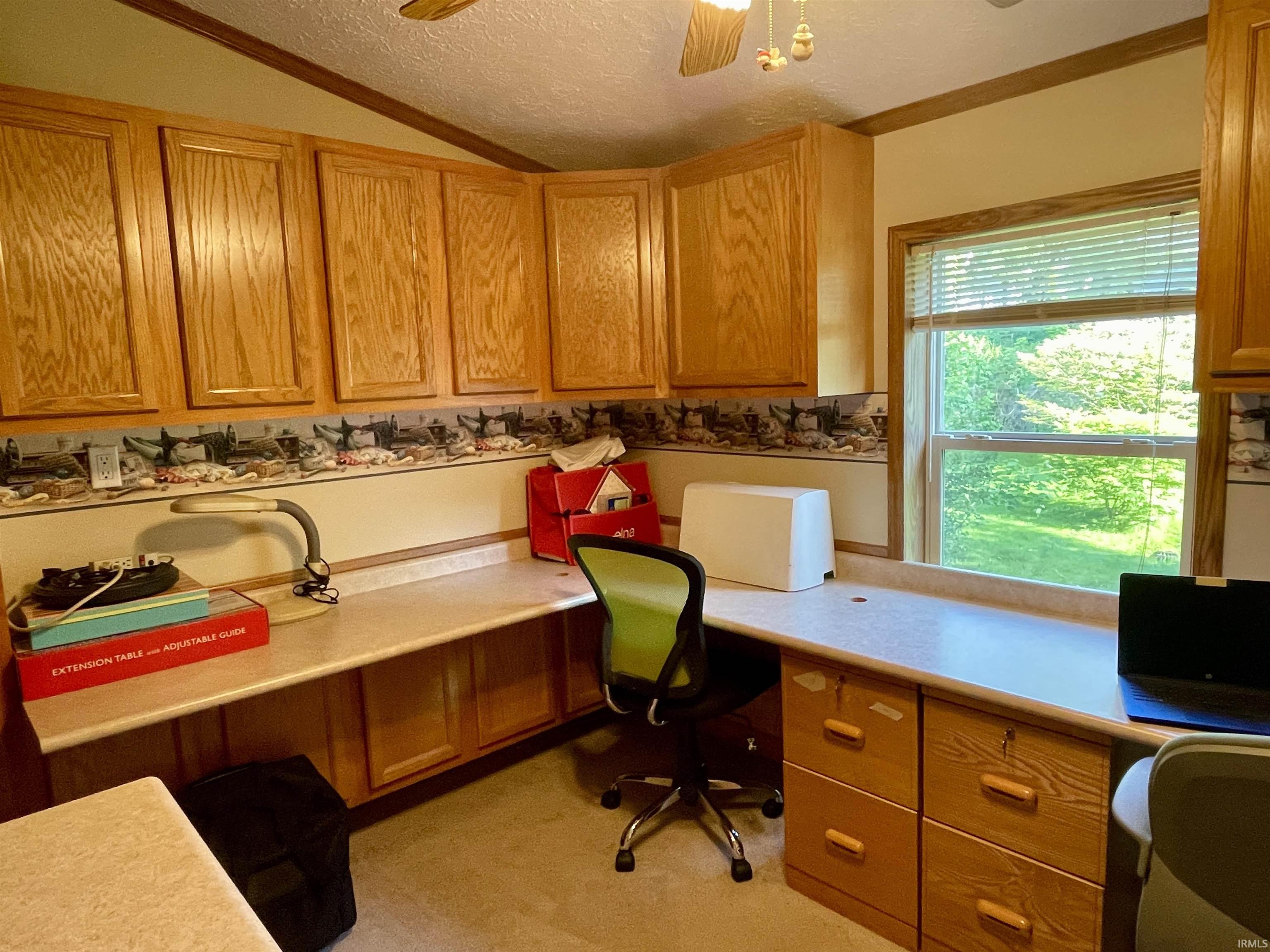 Room featuring built-in wood cabinetry, light-toned countertops, and a window providing natural light