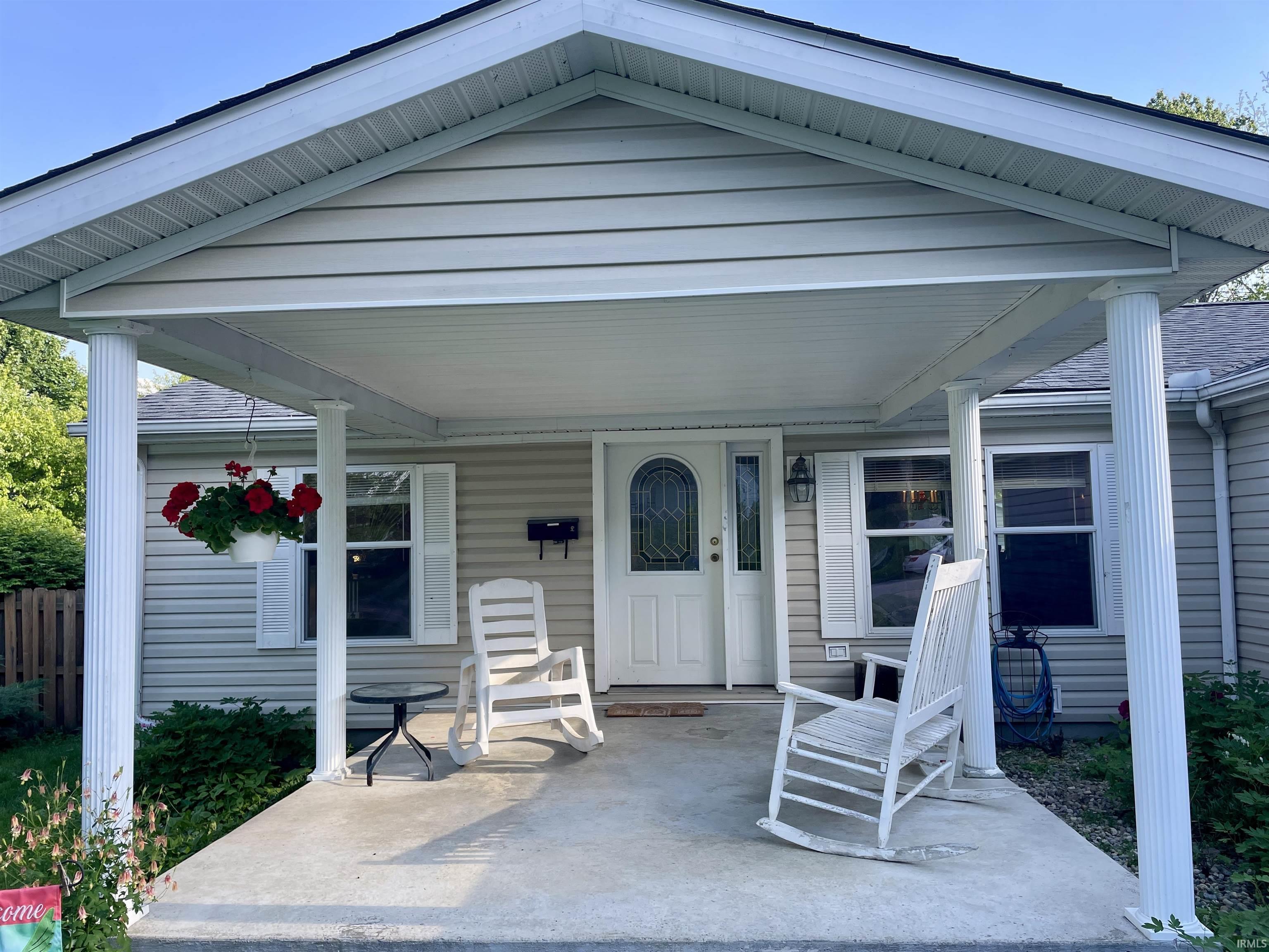 Covered front porch with fluted columns and a concrete slab