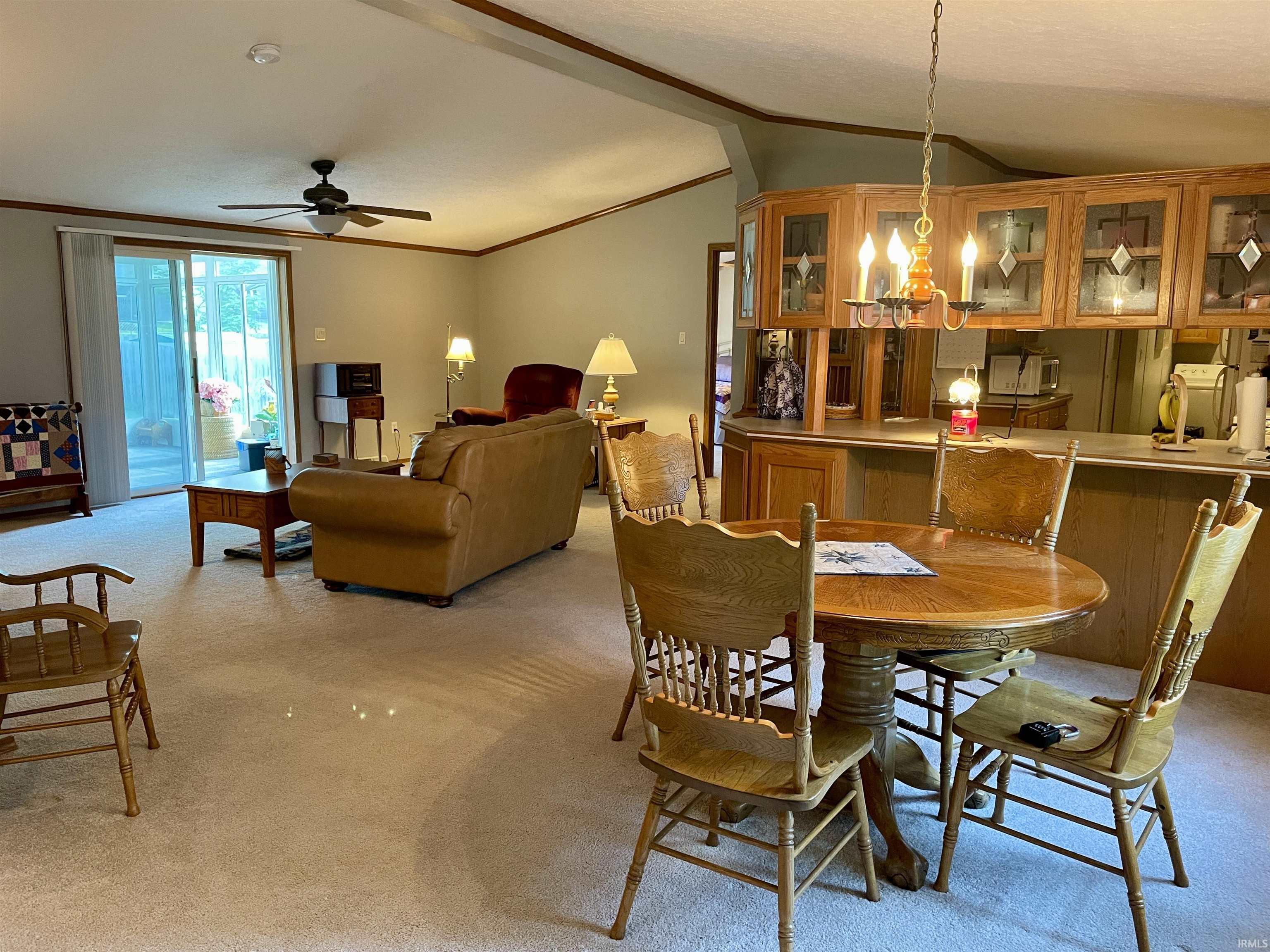 Living area featuring a sliding glass door, ceiling fan, and carpet flooring