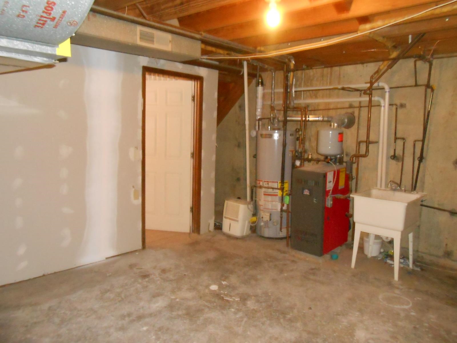 Utility area featuring a water heater, furnace, and a functional laundry sink