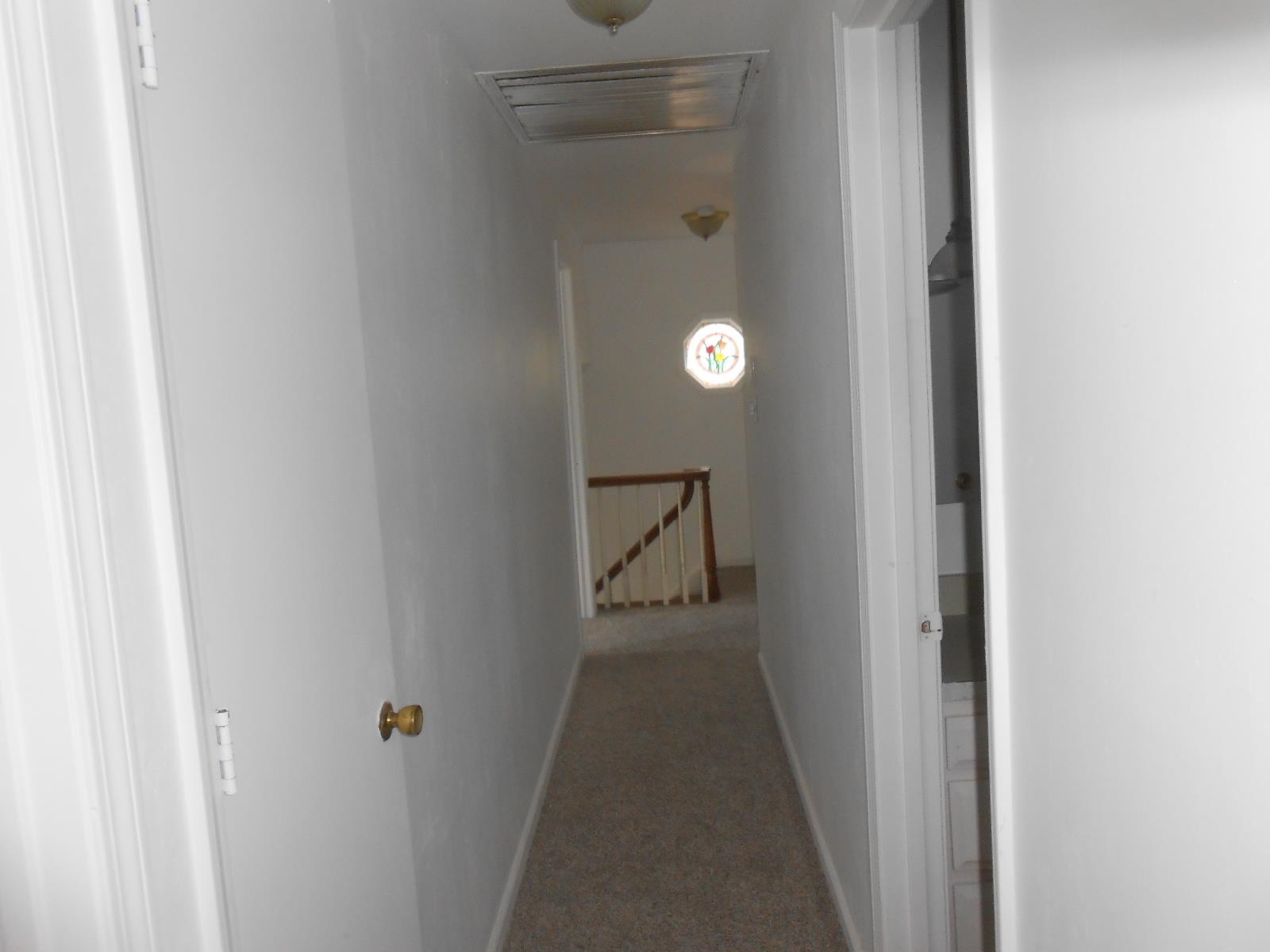 Hallway featuring carpet flooring and light-toned walls