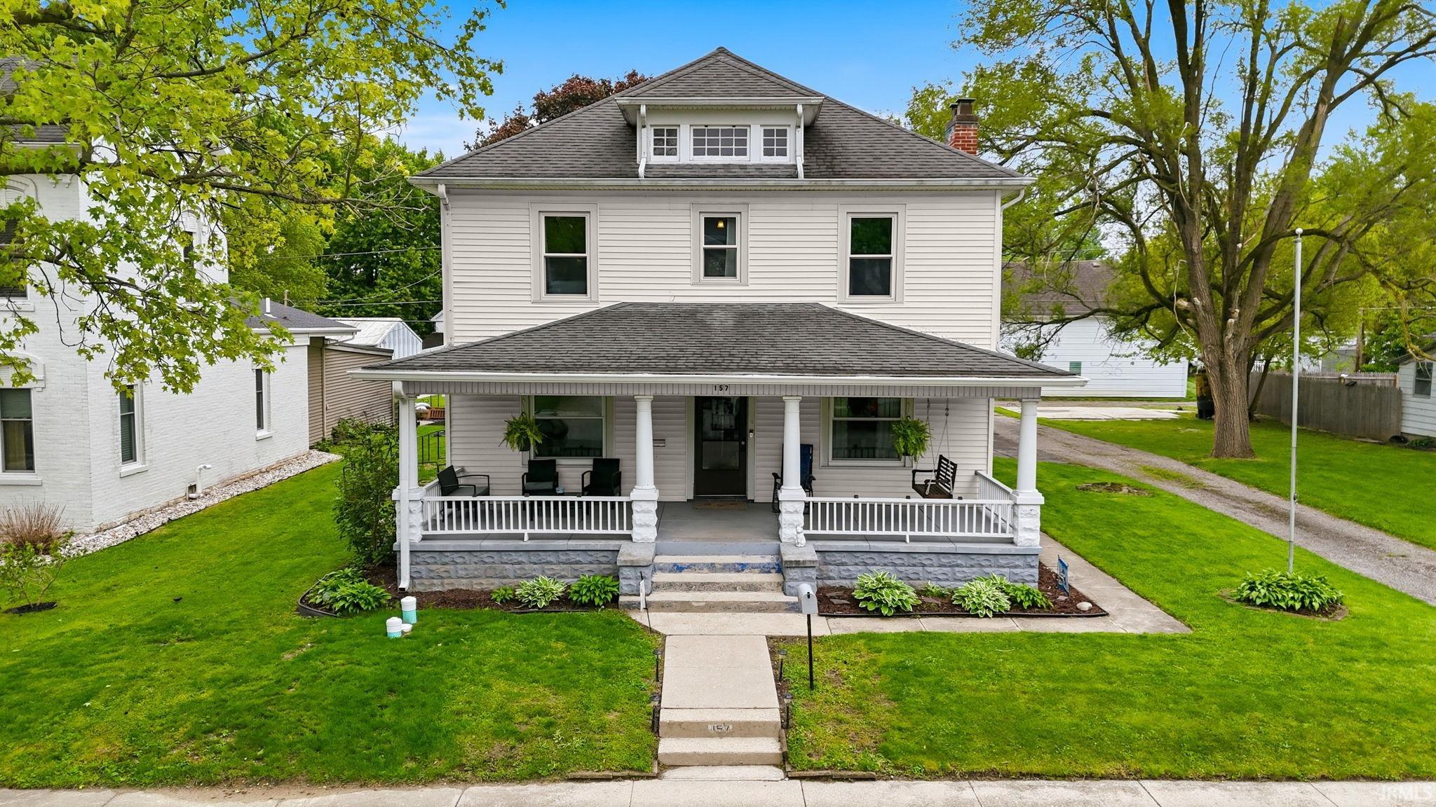 Two-story residence featuring white siding and a covered front porch with white railings