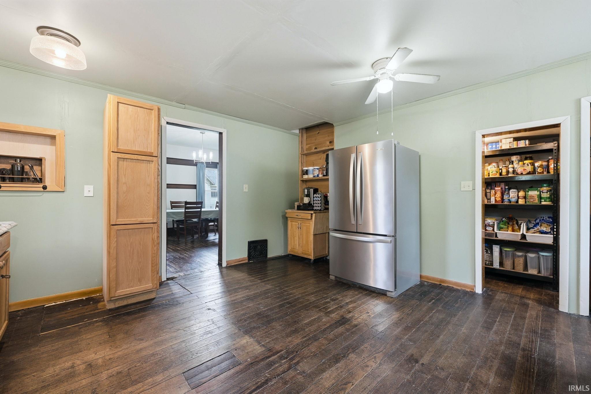 Kitchen featuring dark wood-finish flooring, light green walls, a stainless steel French door refrigerator, and a built-in pantry with shelving