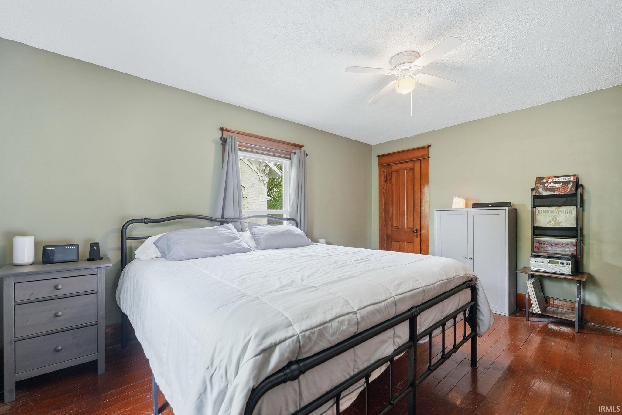 Hardwood flooring, painted walls, and a ceiling fan with integrated lighting