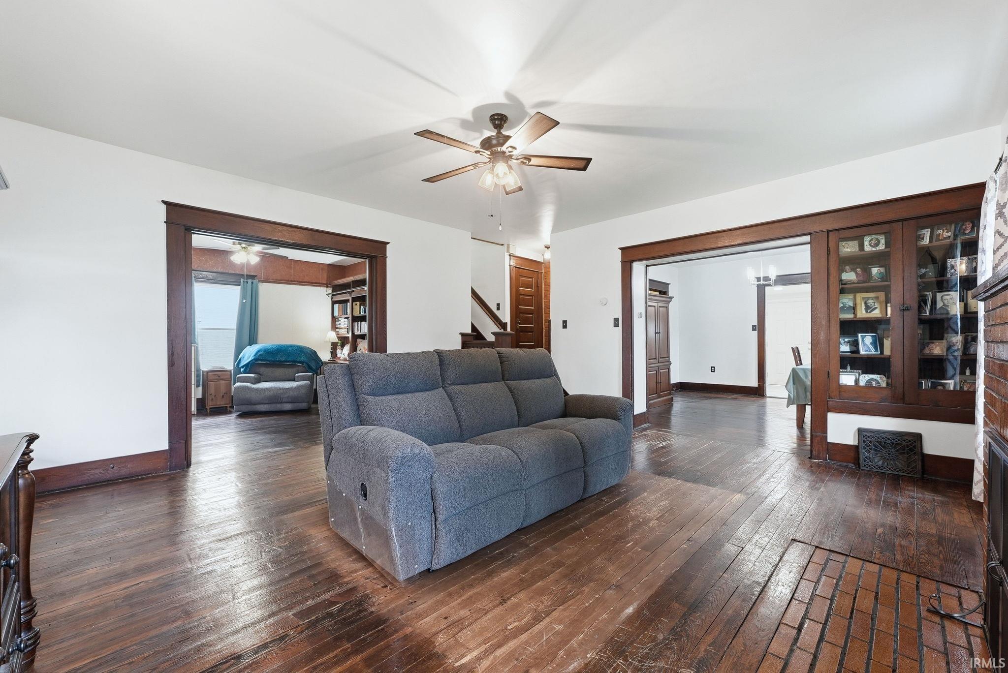 Spacious interior featuring wood-finish flooring, white walls, and a ceiling fan