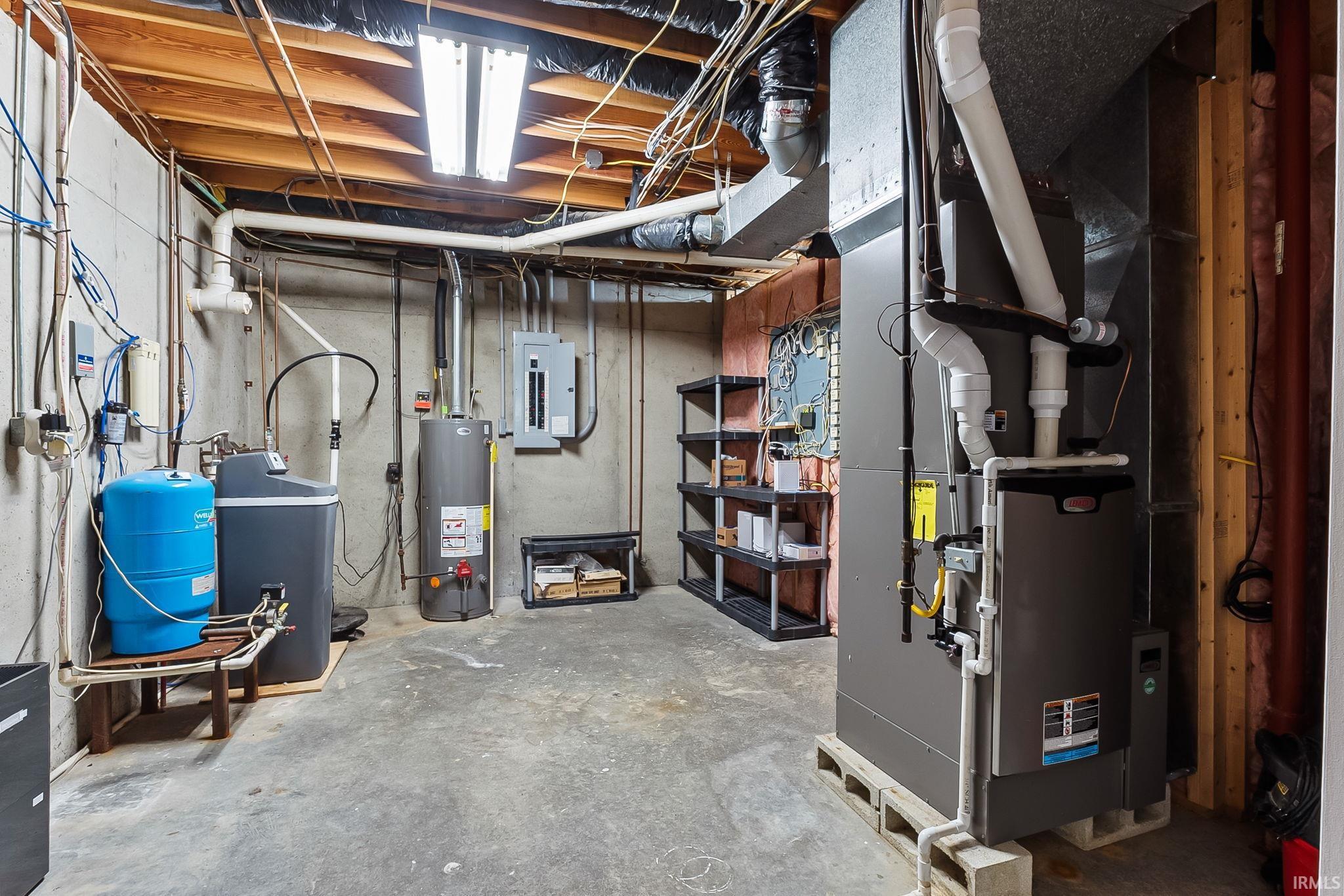 Basement utility room featuring a Lennox furnace, water heater, water softener, and pressure tank