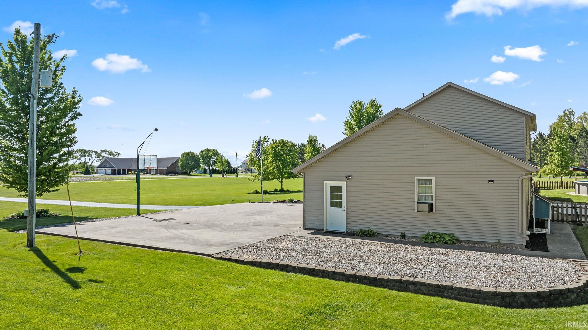 Extensive concrete pad featuring a basketball hoop