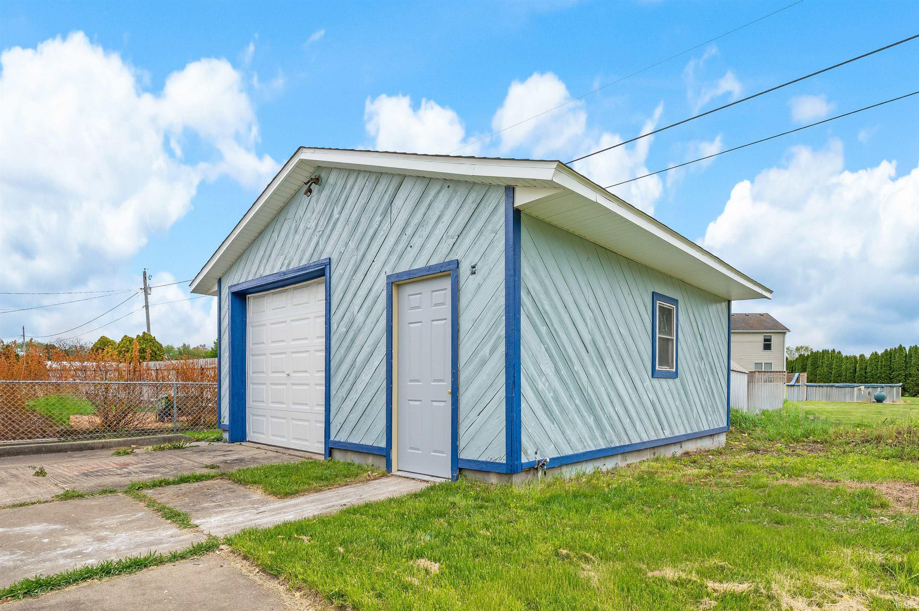 Detached two-car garage with light blue siding and dark blue trim